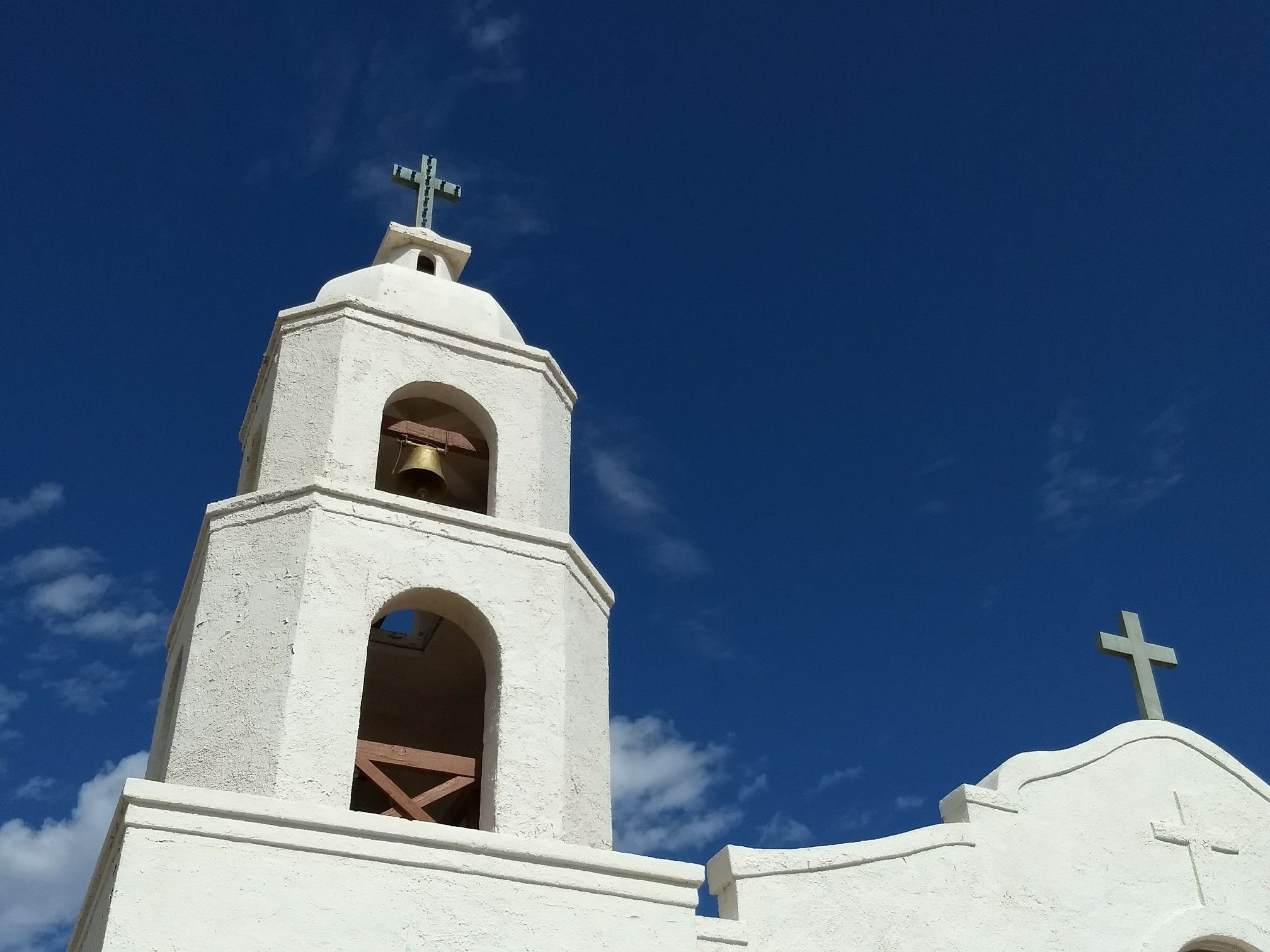White church bell tower with crosses against a bright blue sky. - Sunrise Point Park loop