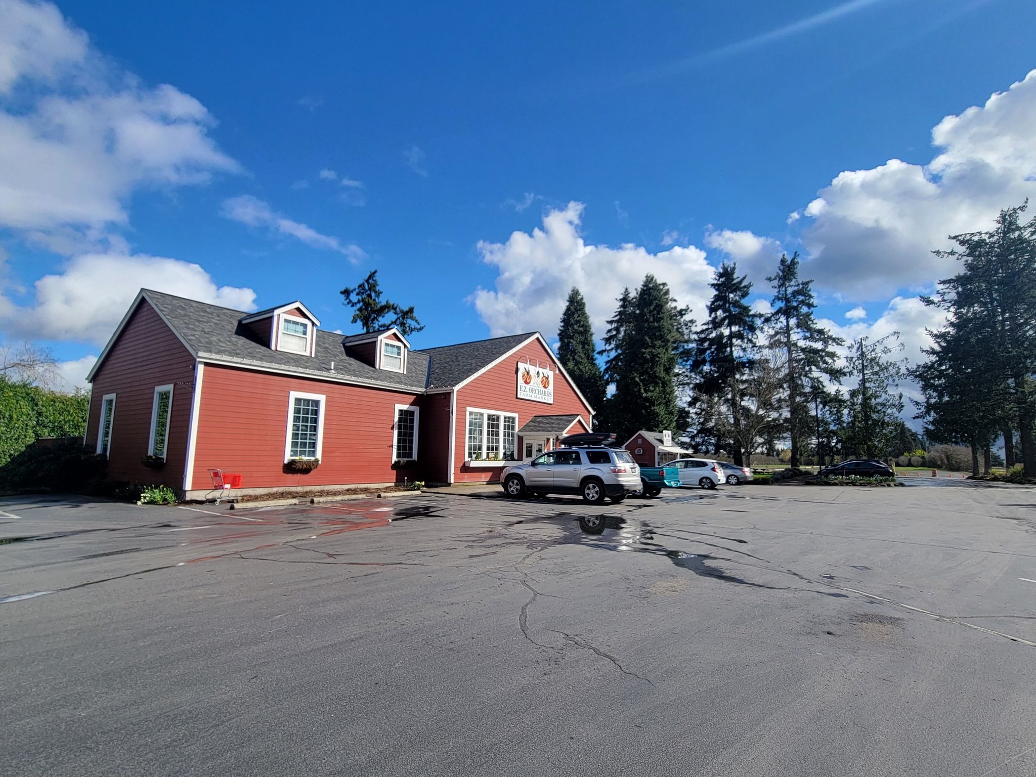 Bright red building with a large parking lot under a sunny blue sky. - Keizer to Mount Angel loop