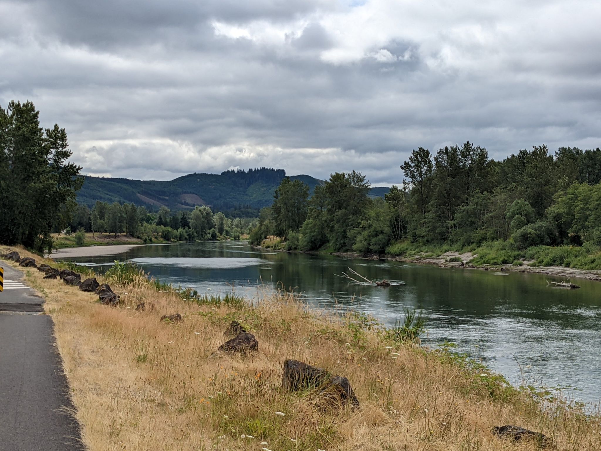River flowing through a forested valley under a cloudy, grey sky. - Rocky Point – Riverfront Trail loop from Kelso-Longview