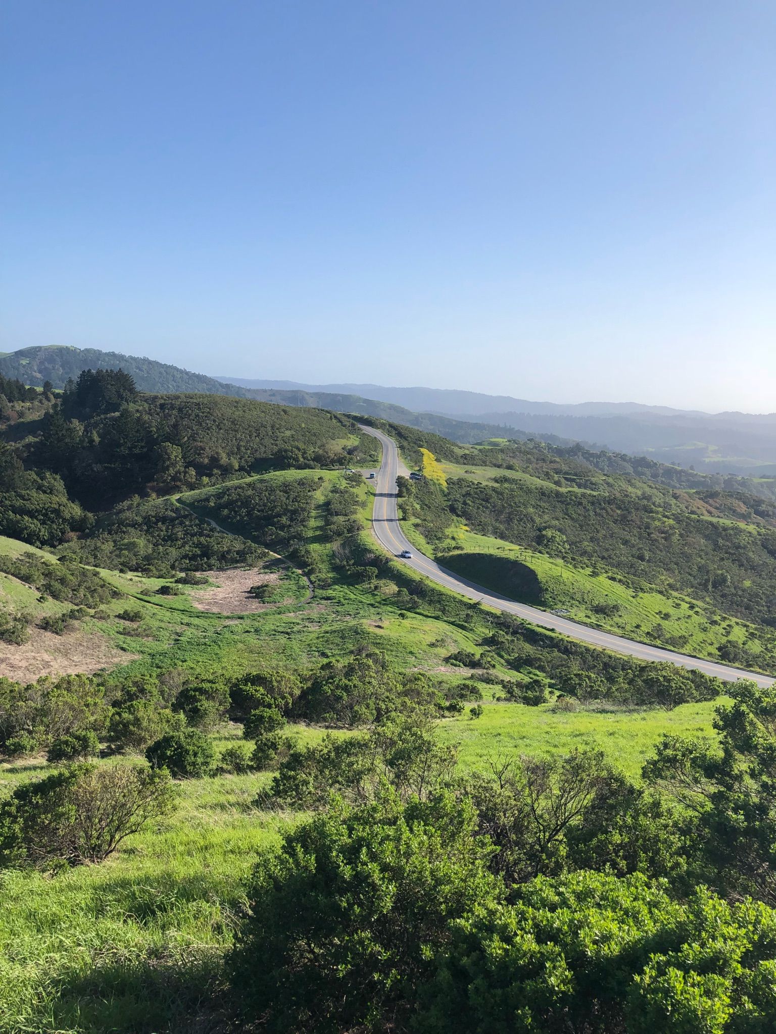 Winding road through green hills under a clear blue sky. - Hamms Gulch to Spring Ridge Loop