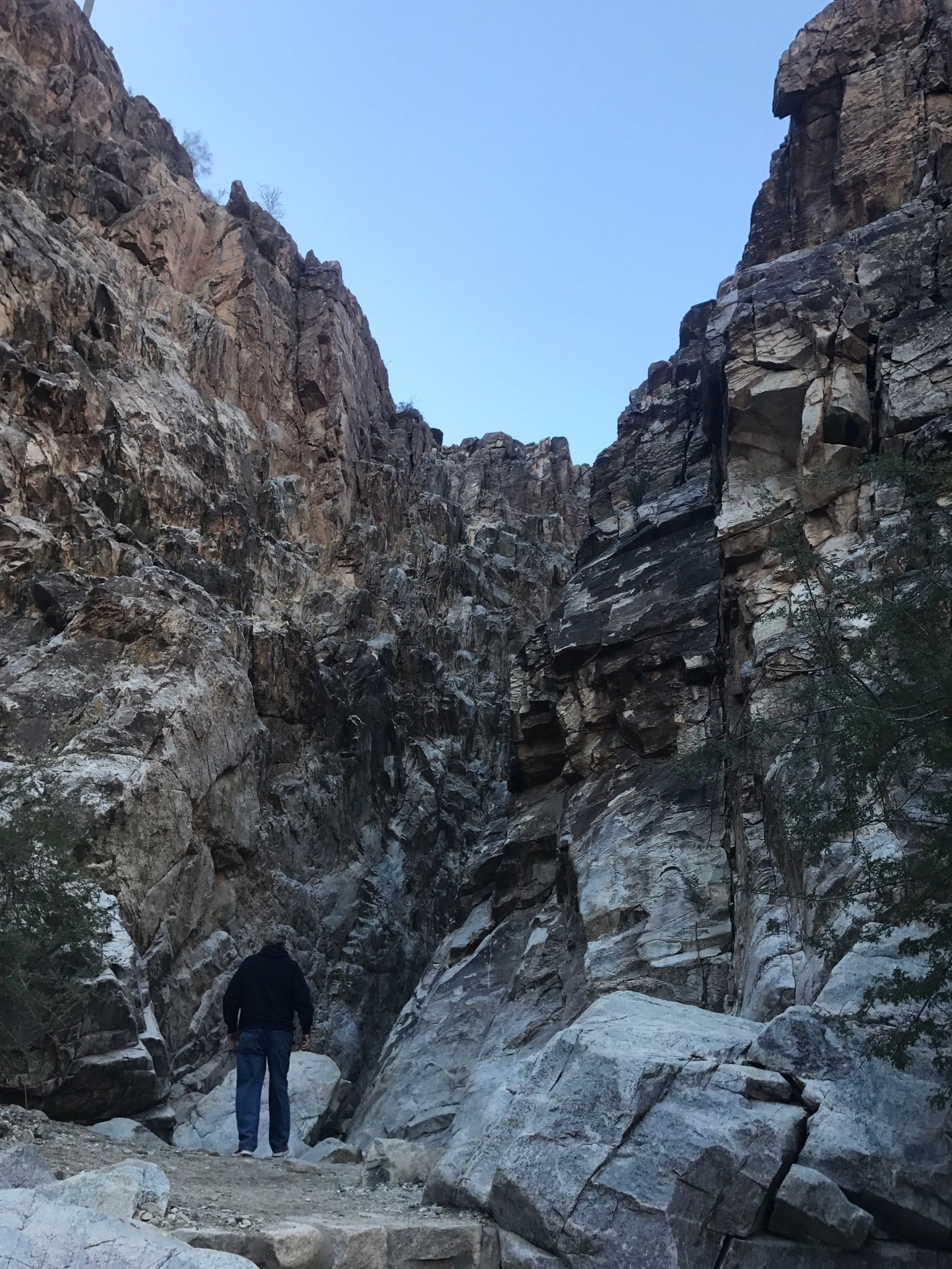 Person stands in a rocky canyon, looking into the narrow gorge at dusk. - Waterfall and Black Rock Long Loop