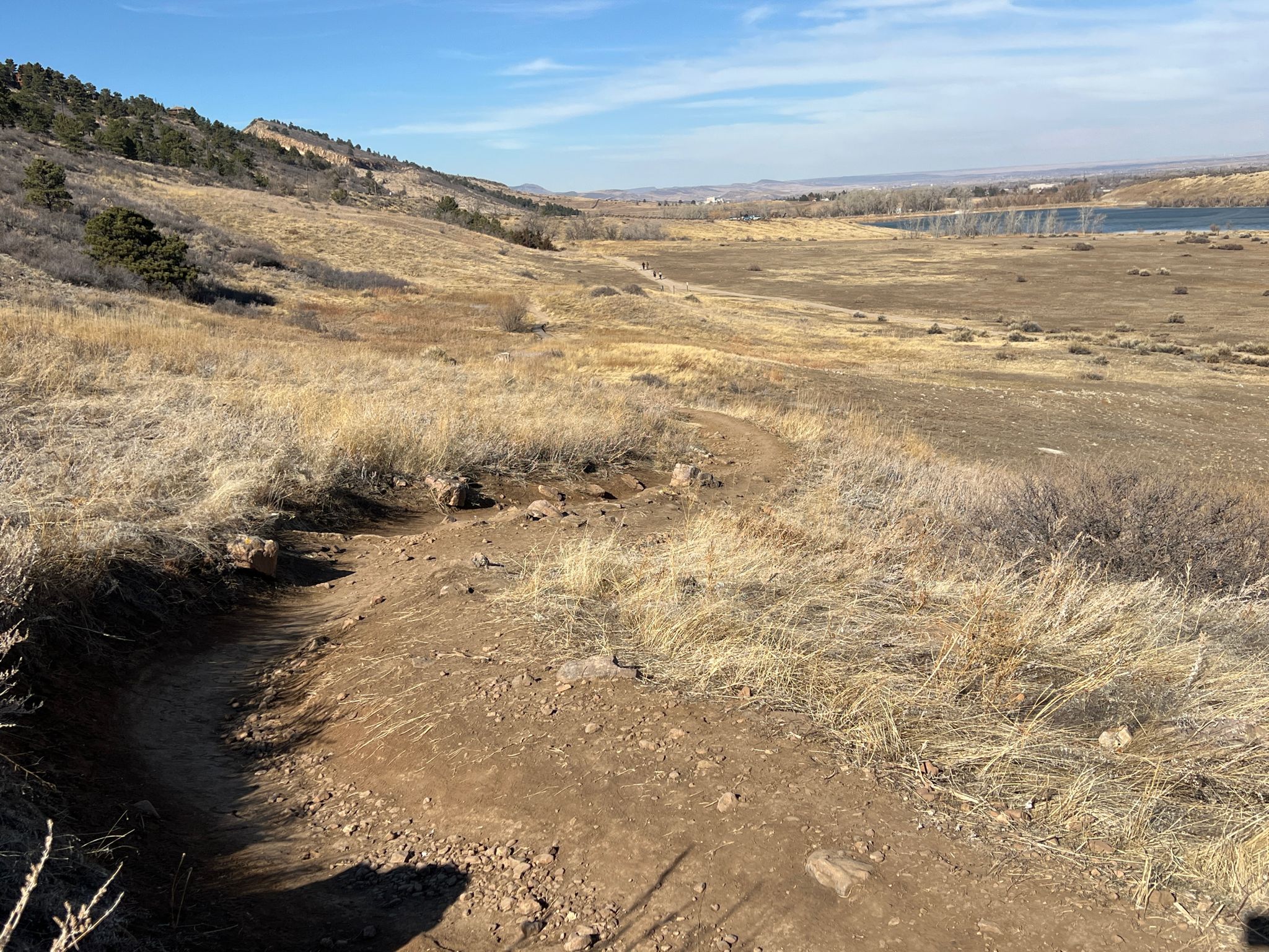 A winding dirt trail through dry, grassy hills with a distant lake. - Pineridge and Dixon Reservoir Loop