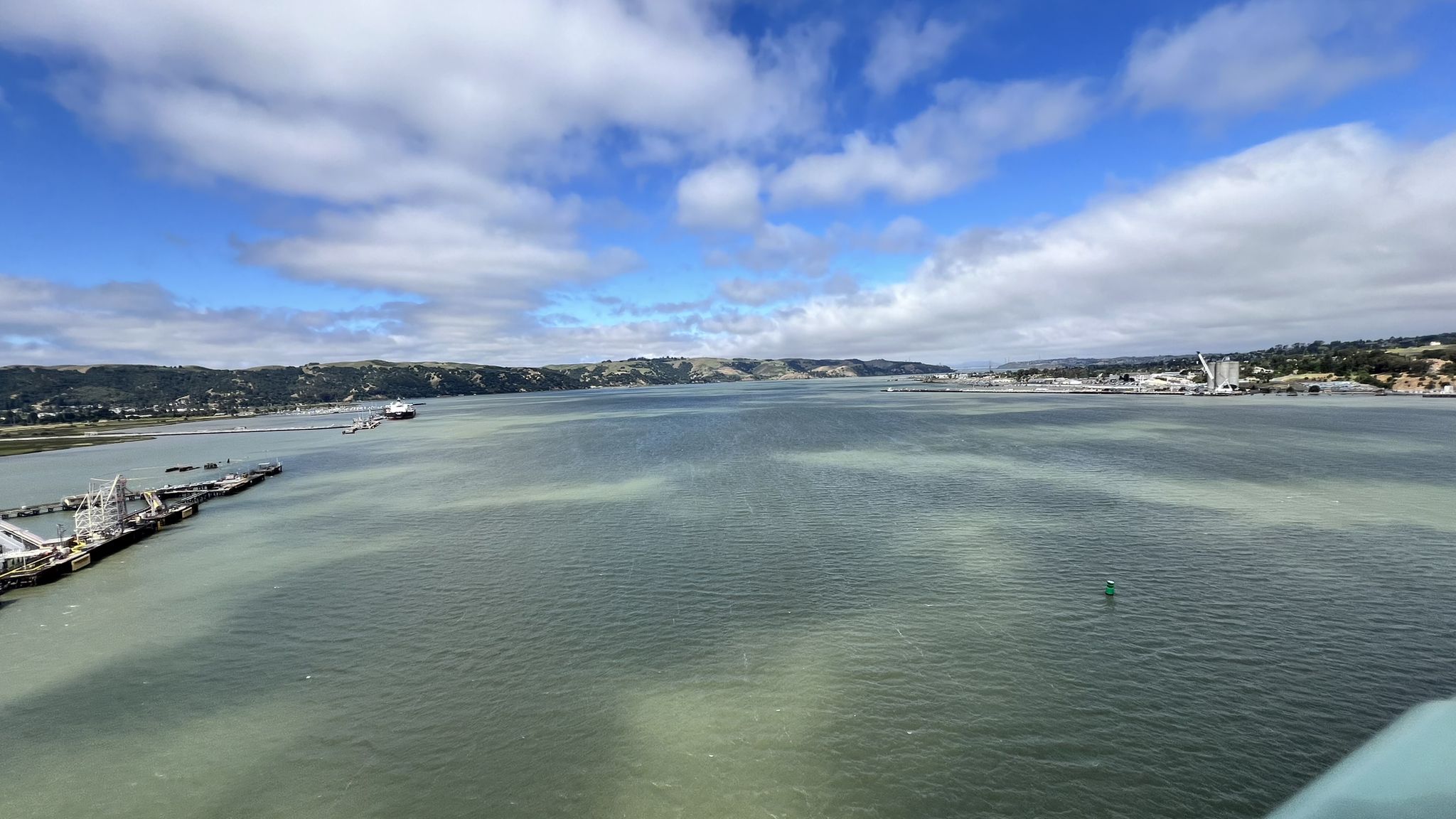Wide body of water with distant land and a ship, under a blue sky. - Bay Area Ridge Trail: Benicia-Martinez Bridge