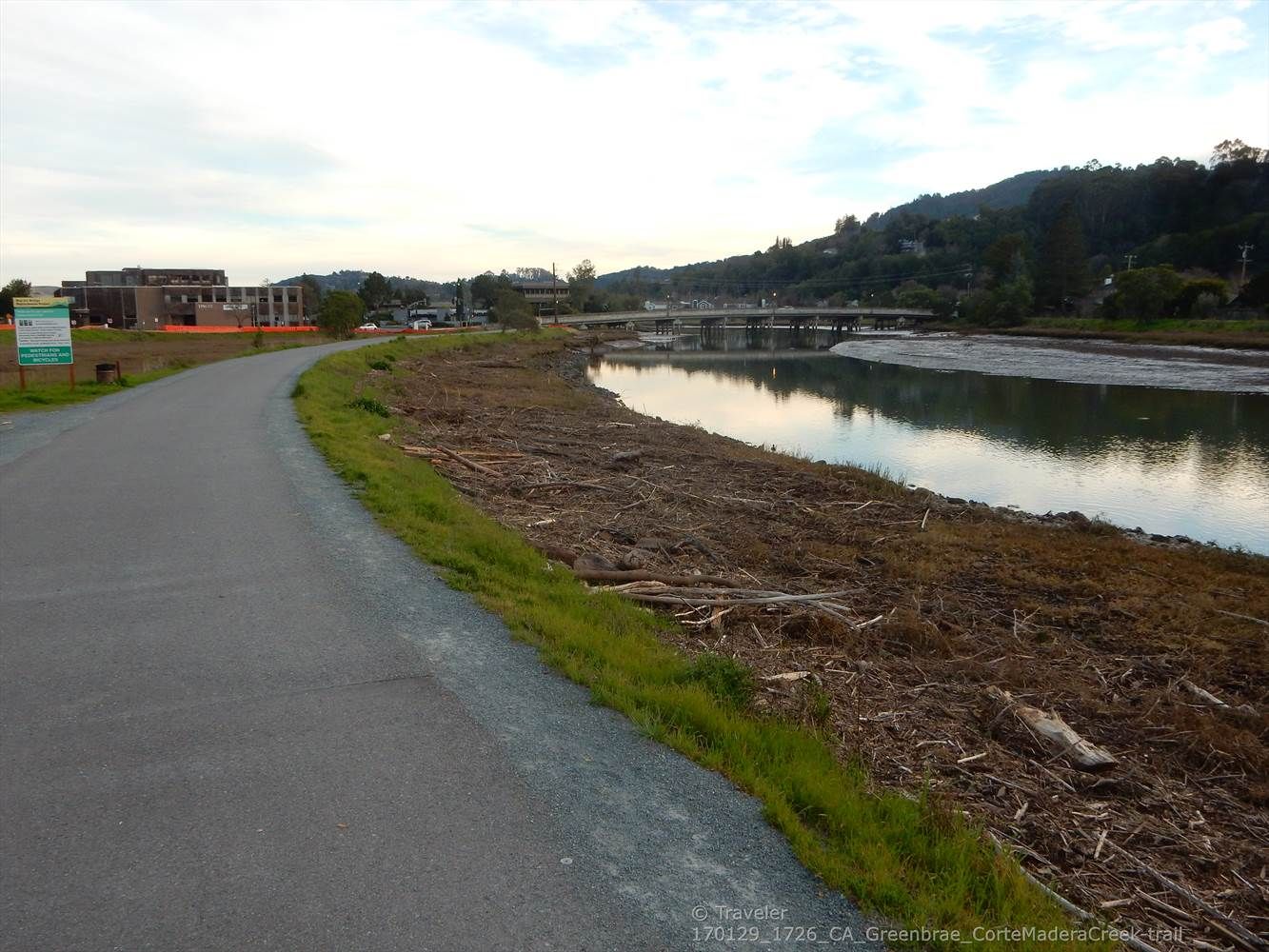 Paved path alongside a river with dry vegetation and a distant bridge. - Corte Madera Pathway – Corte Madera Multi-Use Path loop from San Rafael