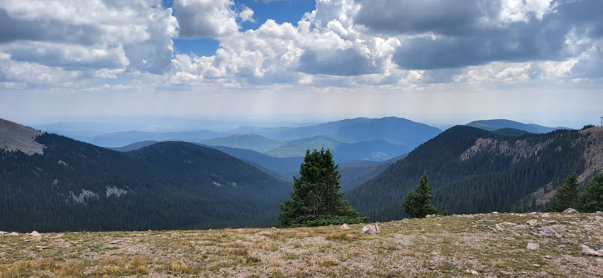 An expansive view of rolling mountain ranges fading into the distance under clouds. - Santa Fe Ski Basin