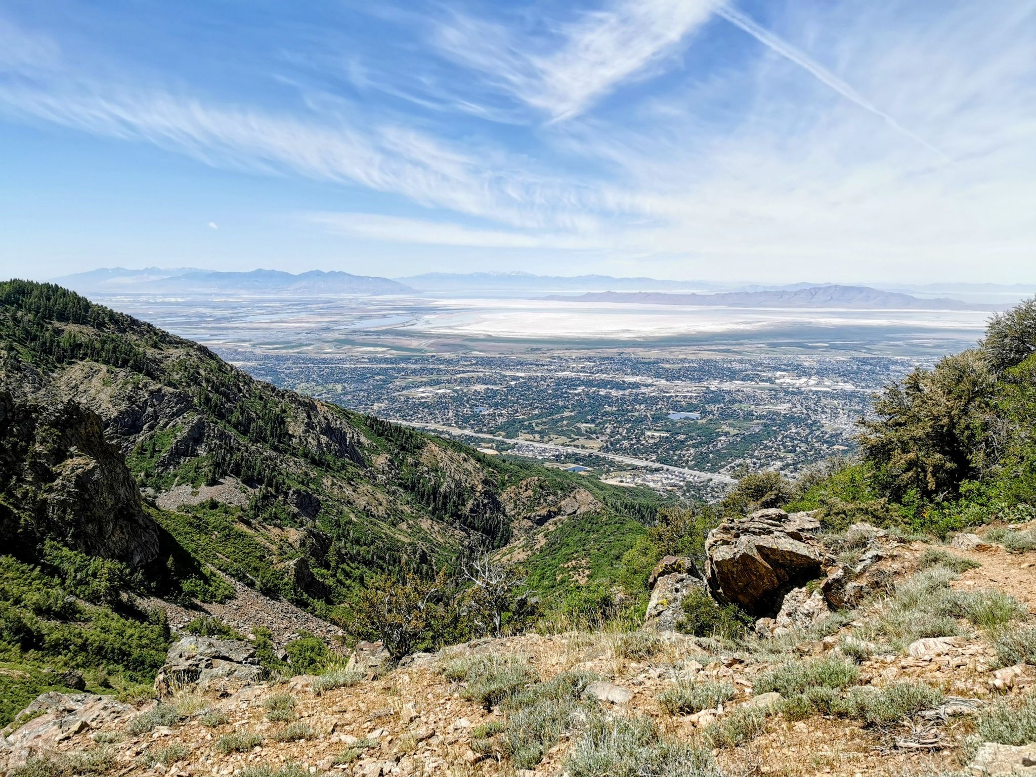 Mountain vista overlooking a city and distant lake under a blue sky. - Thurston Peak via Adams Cabin Trail
