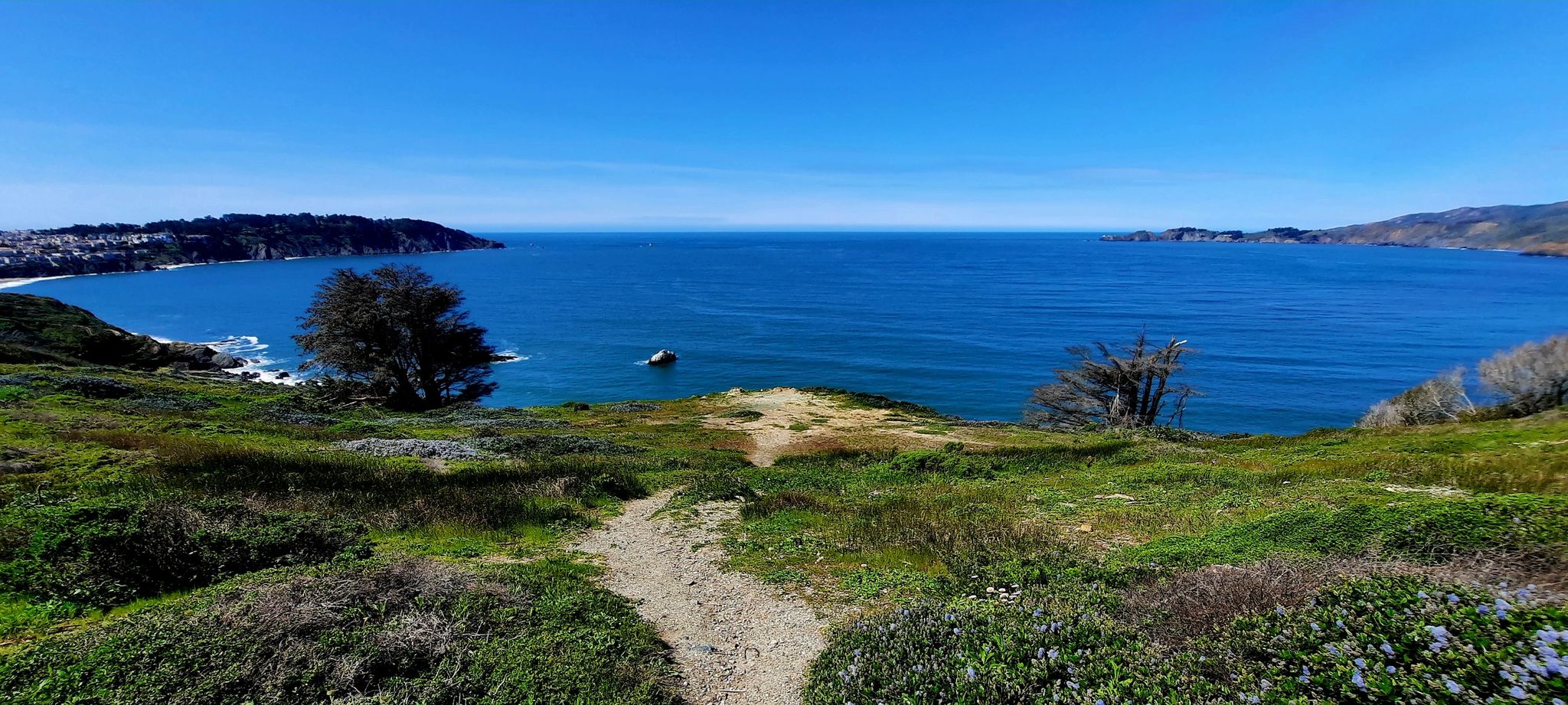 Dirt path leads down to a wide blue bay on a sunny day. - Golden Gate Park, Lands End and Presidio Loop