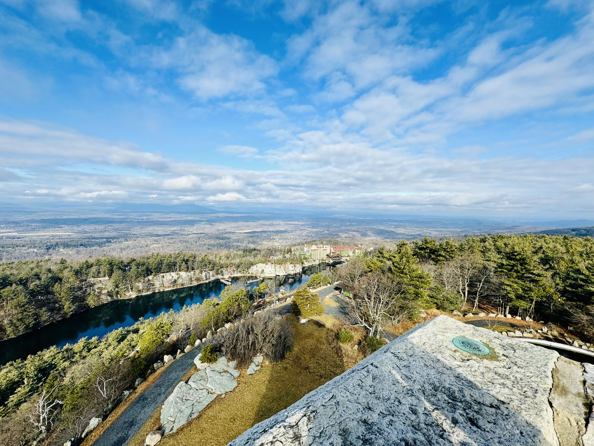 Panoramic view of a lake and forest from a rocky cliff on a sunny day. - River-to-Ridge to Skytop Tower Loop