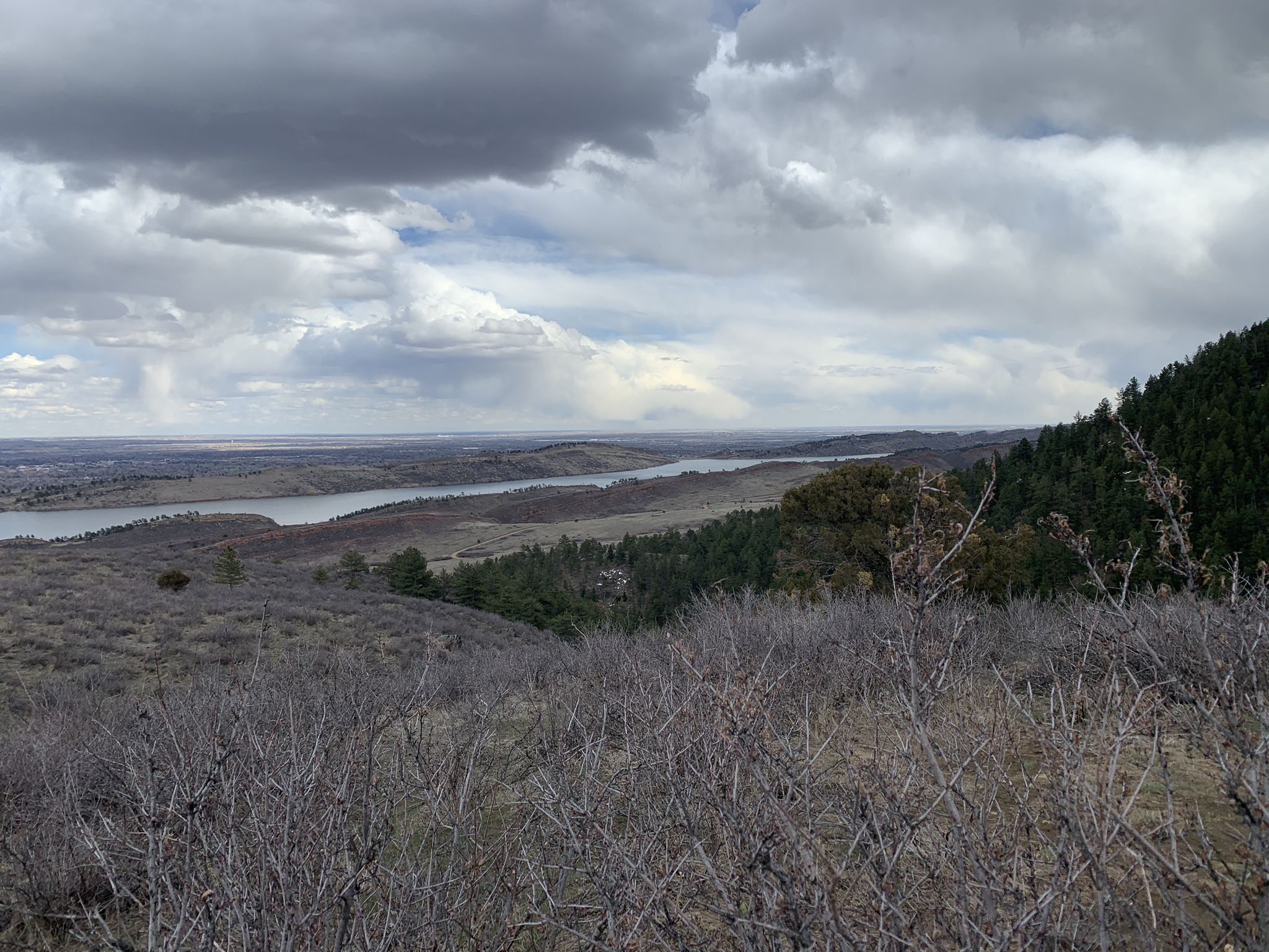 Overcast sky above a wide landscape with a lake, hills, and sparse trees. - Arthur's Rock loop from Lory State Park