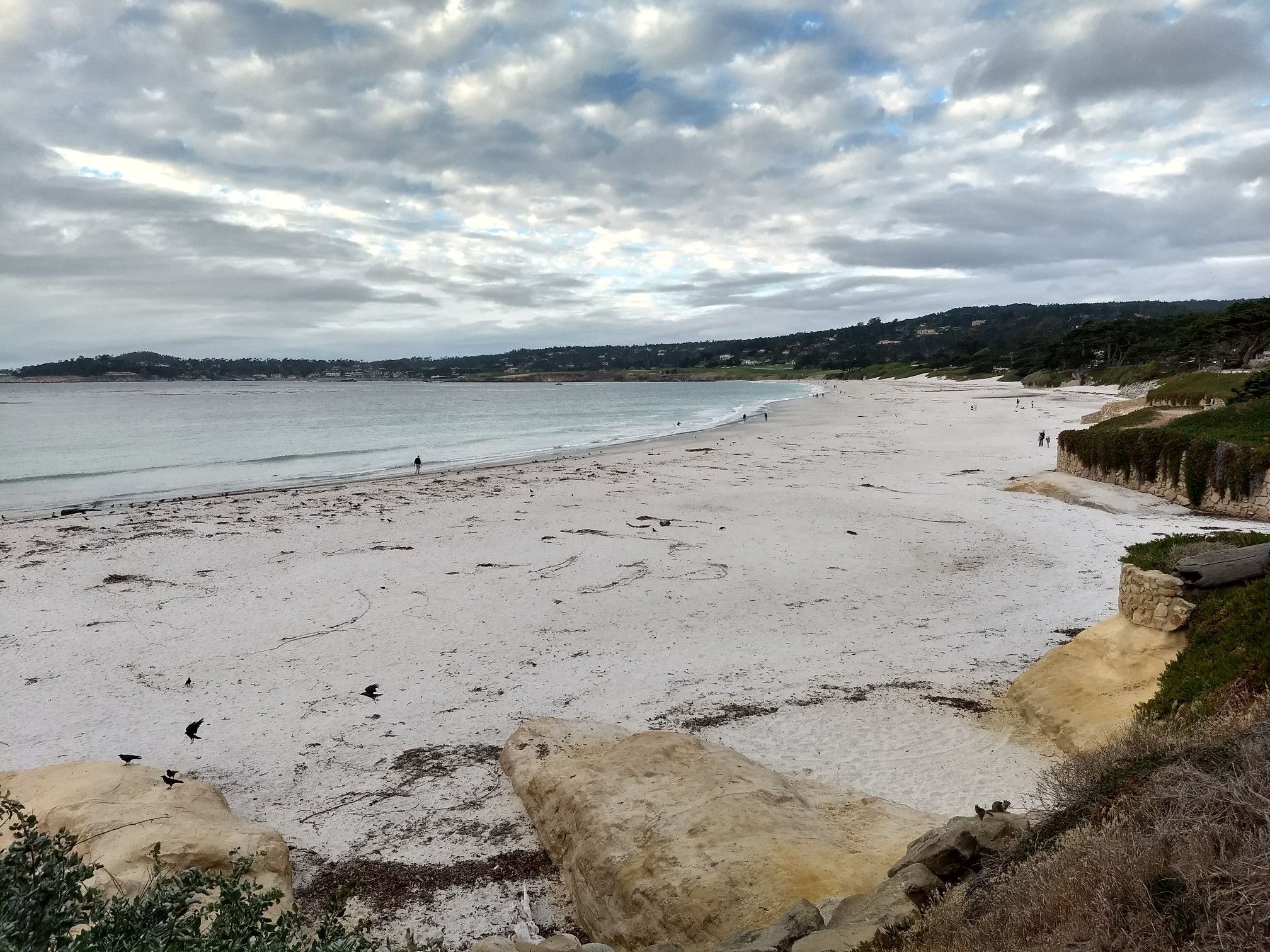 Wide sandy beach under cloudy sky with distant hills and few people. - Carmel Beach City Park – Carmel Beach loop from Carmel-by-the-Sea