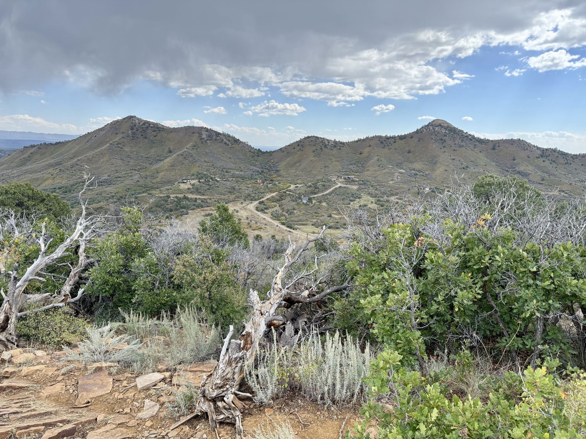 Overcast sky above rolling mountains with scrub brush and dirt roads. - Raiders Ridge Trail