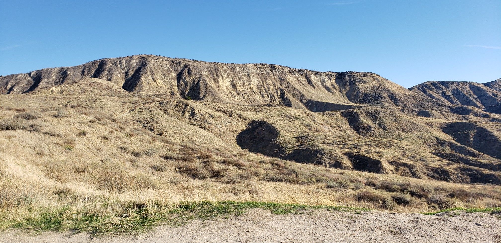 A wide, rugged mountain with dry, rocky slopes under a clear sky. - Tapo Canyon Trail Loop