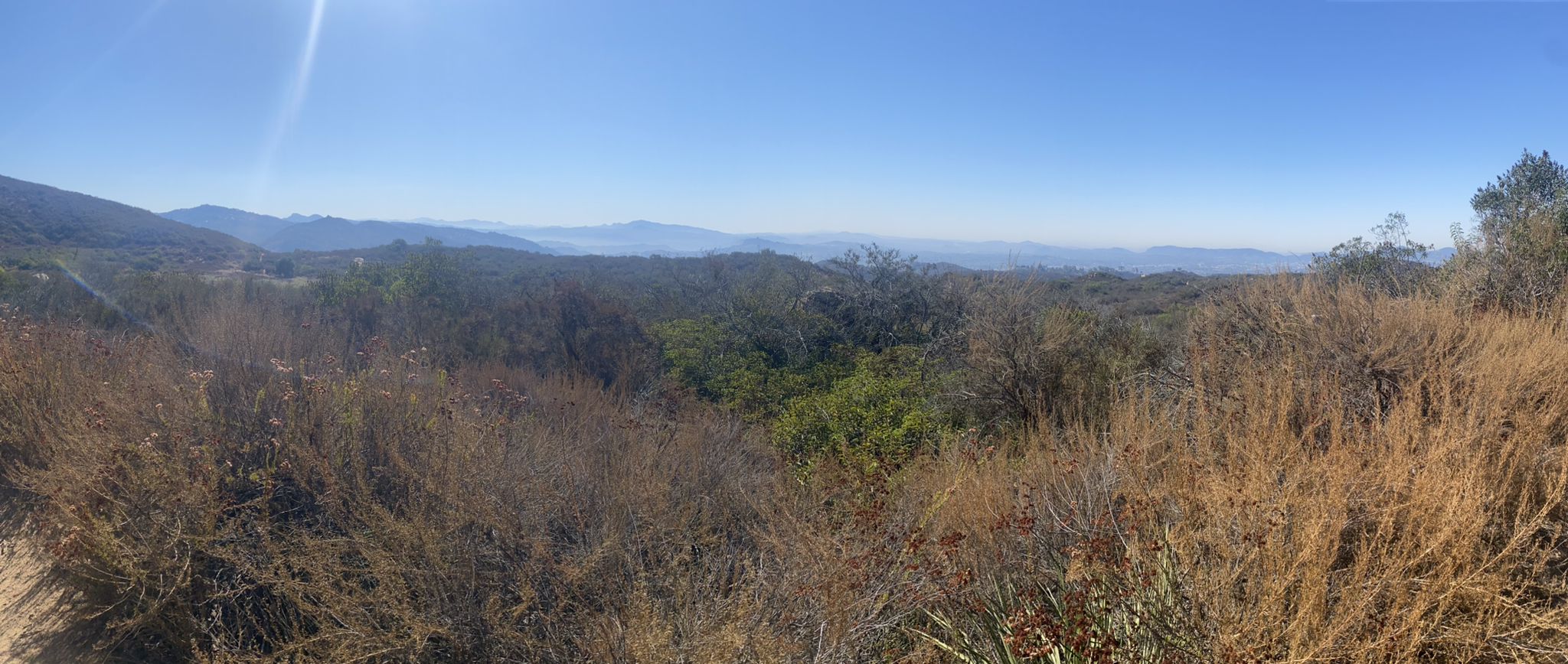 Panoramic view of dry brush, green hills, and distant mountains under a bright sky. - Stanley Peak loop from Mayflower Dog Park