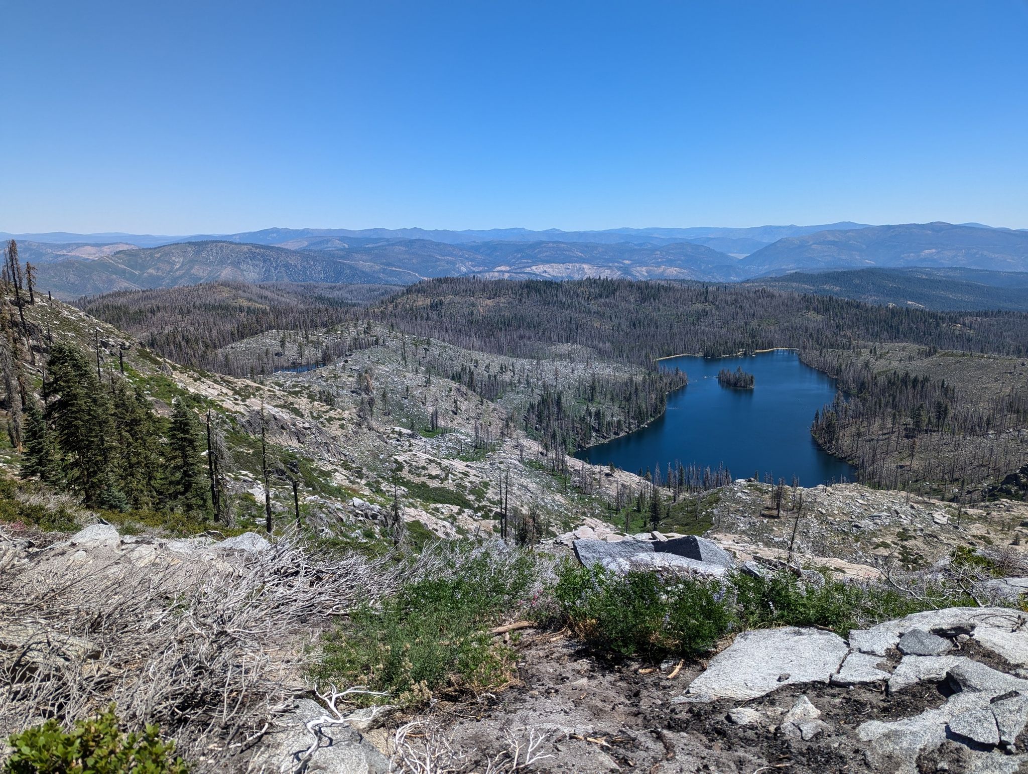 Panoramic view of a blue lake nestled in a vast, rocky, forested landscape. - Gold Lake and Pacific Crest Trail Loop