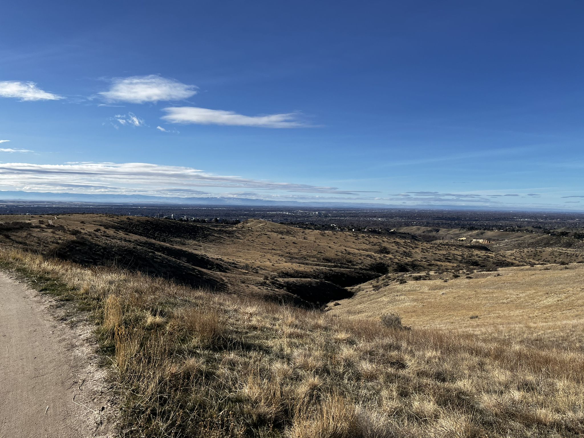 Wide view of dry hills and a distant valley under a blue sky. - Crestline, Sidewinder, and Red Cliffs Loop