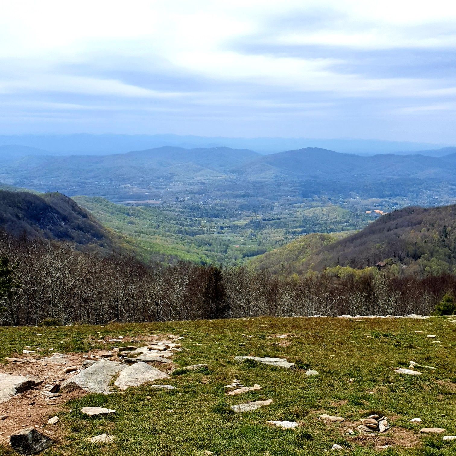 Overcast mountain vista with a green valley and rocky foreground. - Wildcat Rock Trail