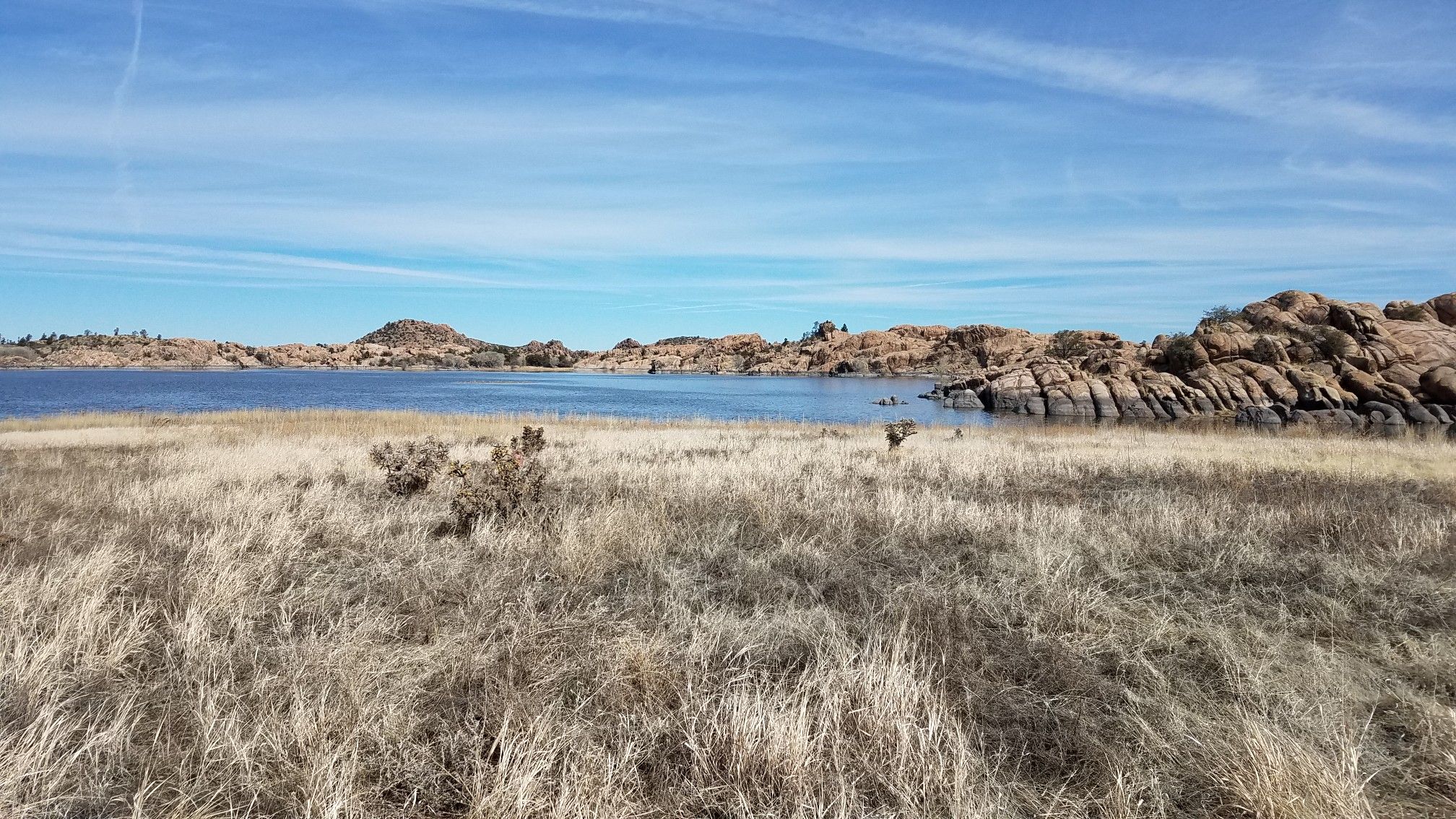 Wide view of a large lake with rocky shores and dry grassy foreground. - Prescott Circle Trail: Segment 10