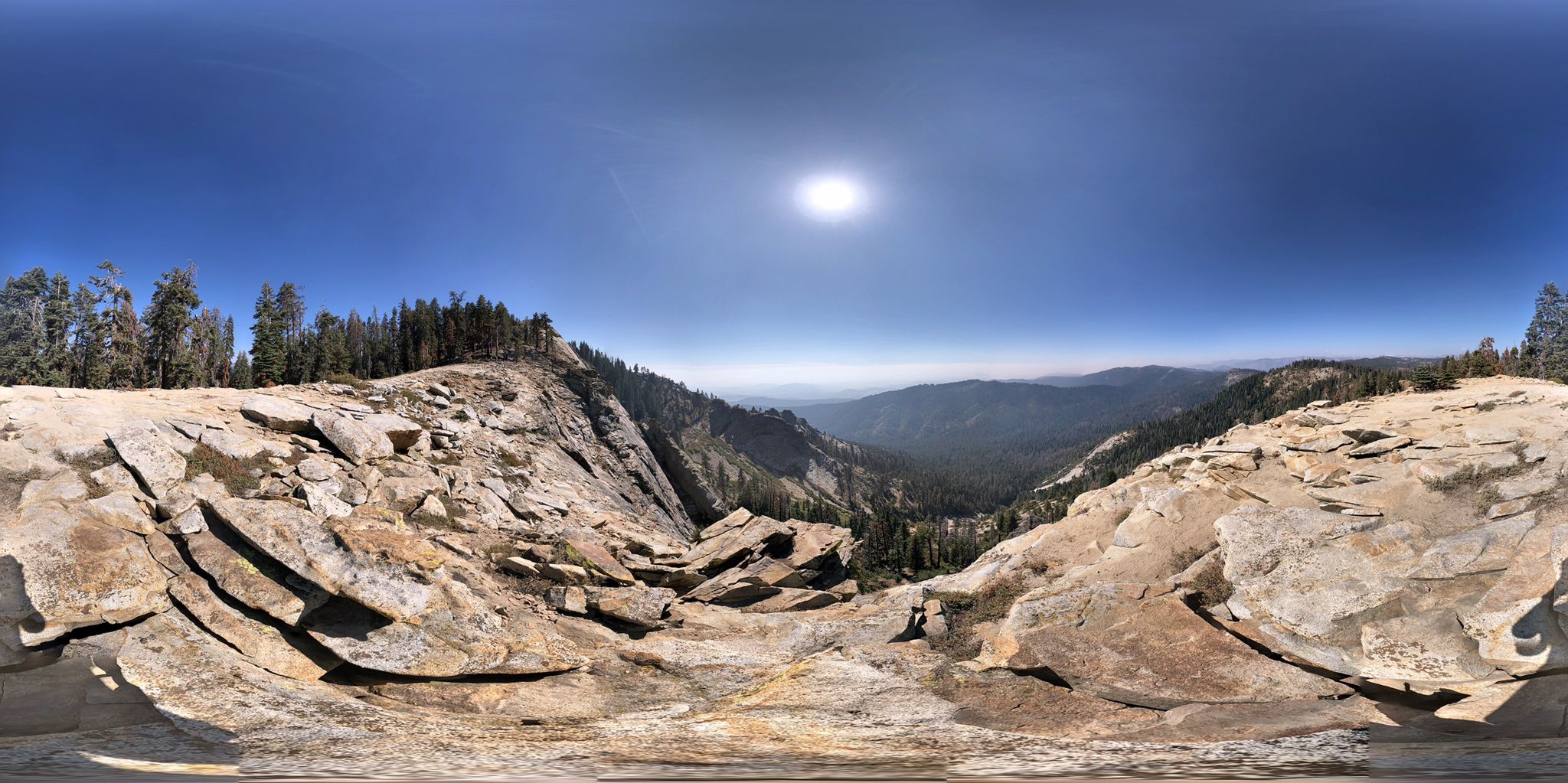 Panoramic view of a vast rocky mountain landscape under a bright sun. - Big Baldy Ridge Trail