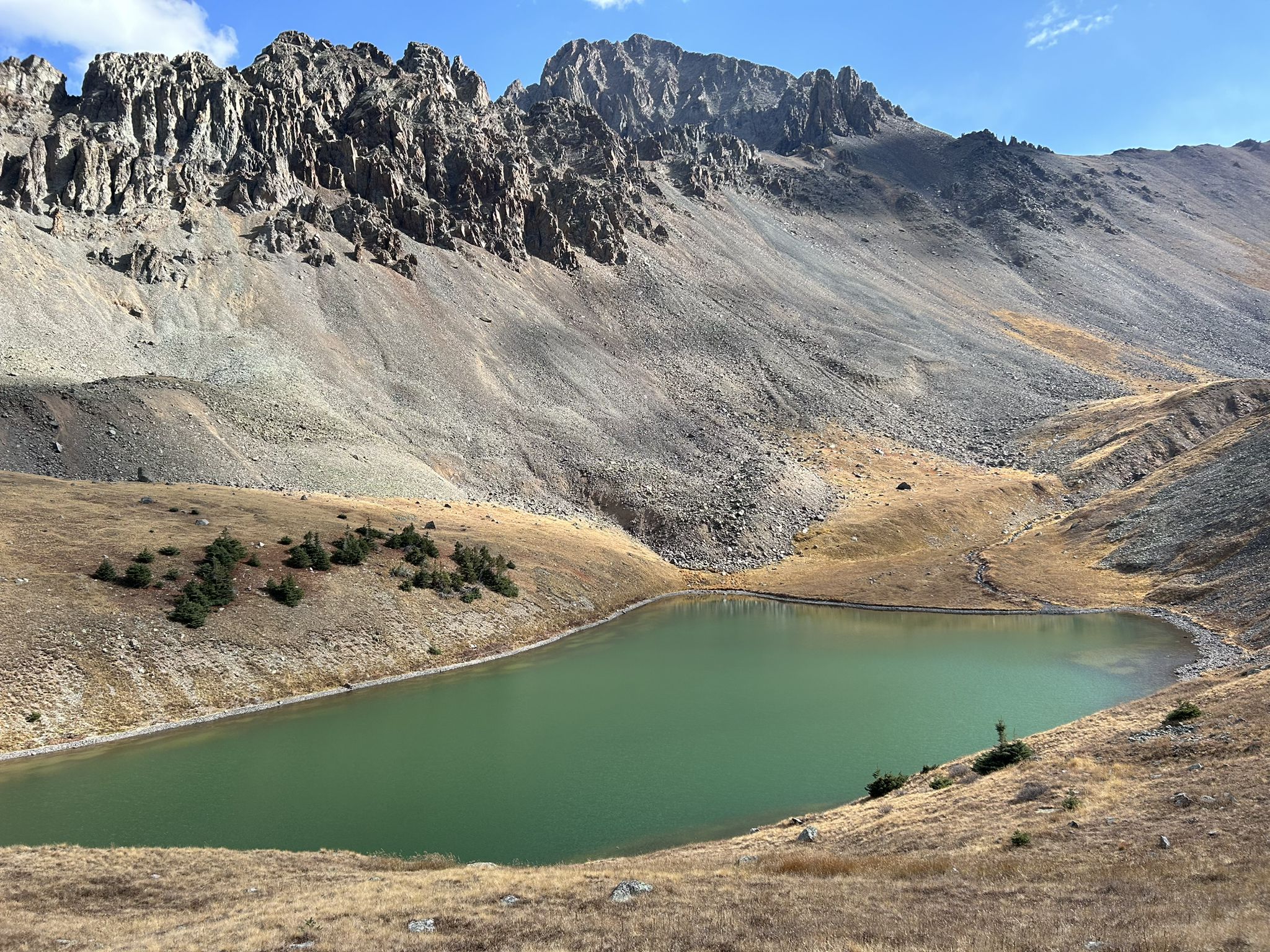 Green alpine lake at the base of rugged, rocky mountains under a bright sky. - Lower Blue Lake – Upper Blue Lake loop from Dallas Peak