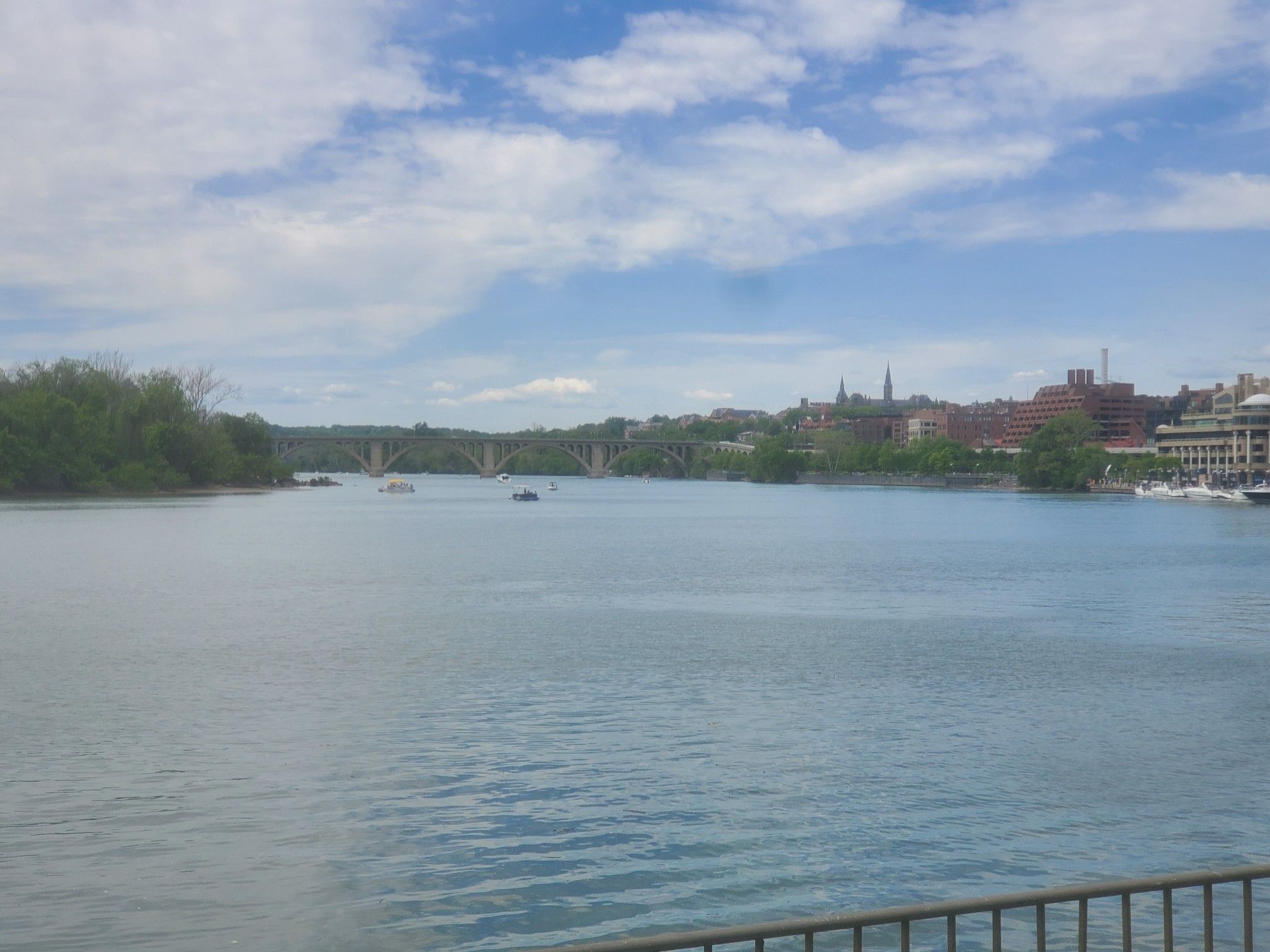 Wide river with distant city buildings and bridges under a cloudy sky. - Peirce Mill loop from Friendship Heights