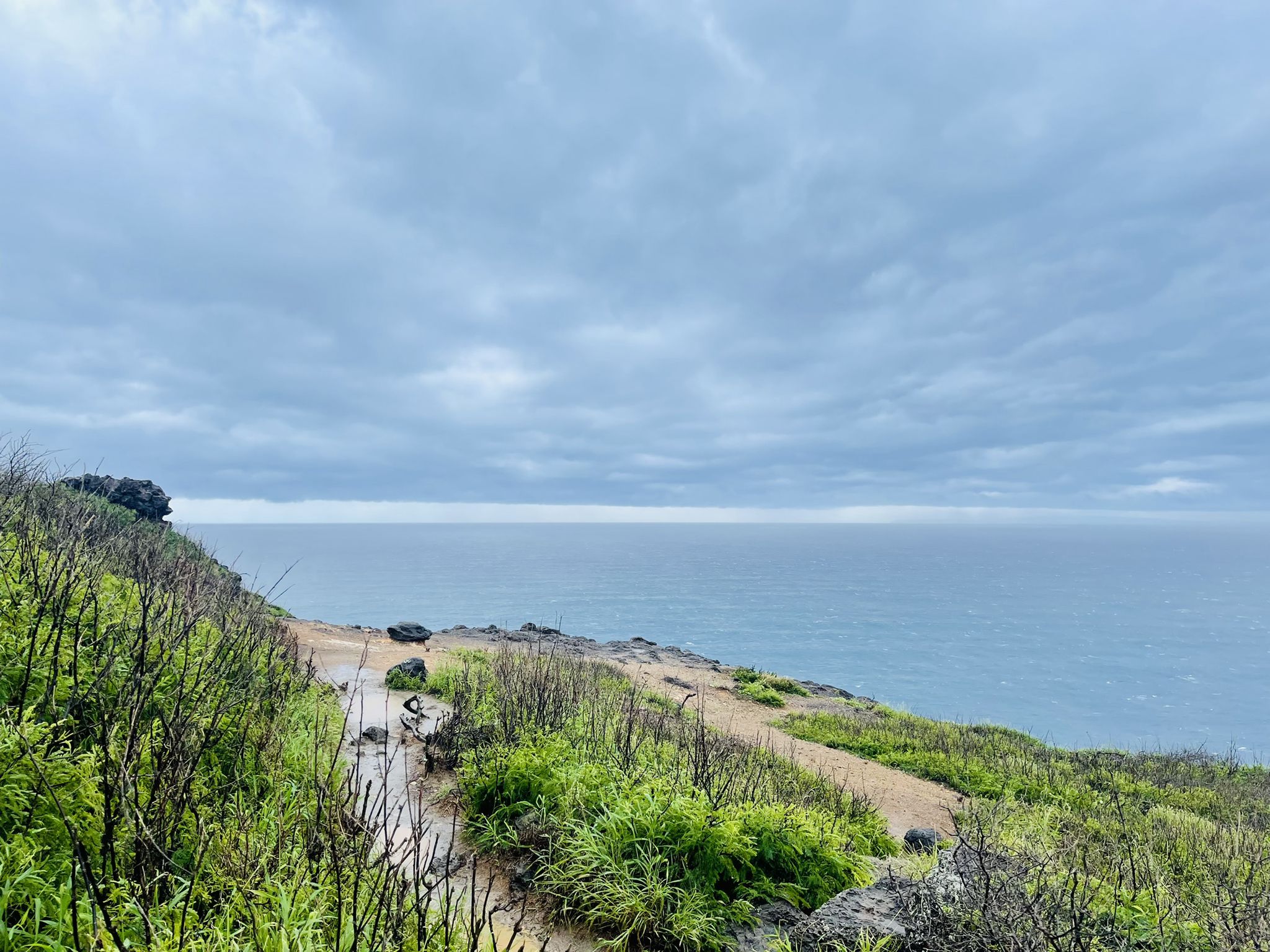 Dirt path along a grassy cliff overlooking a cloudy ocean. - Makapu'u Point Trail (Makapu'u Head and Makapu'u lighthouse) – Kaiwi State Scenic Shoreline