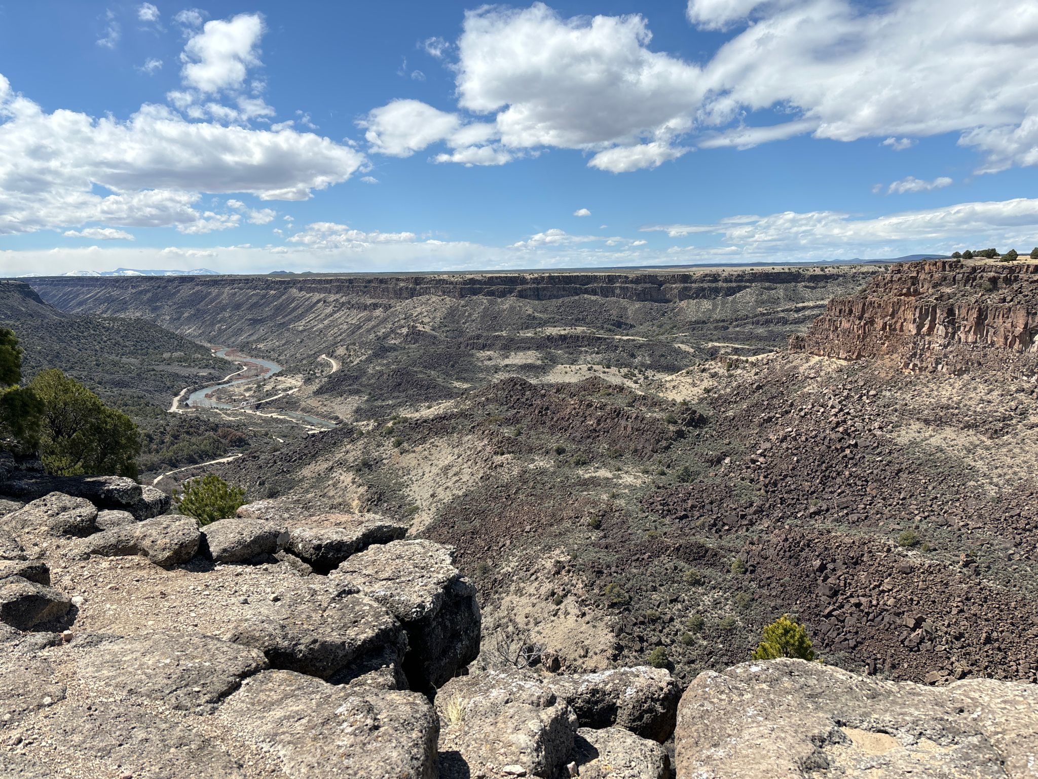 Vast rocky canyon with a winding river under a bright, cloudy sky. - Rift Valley Loop Trails