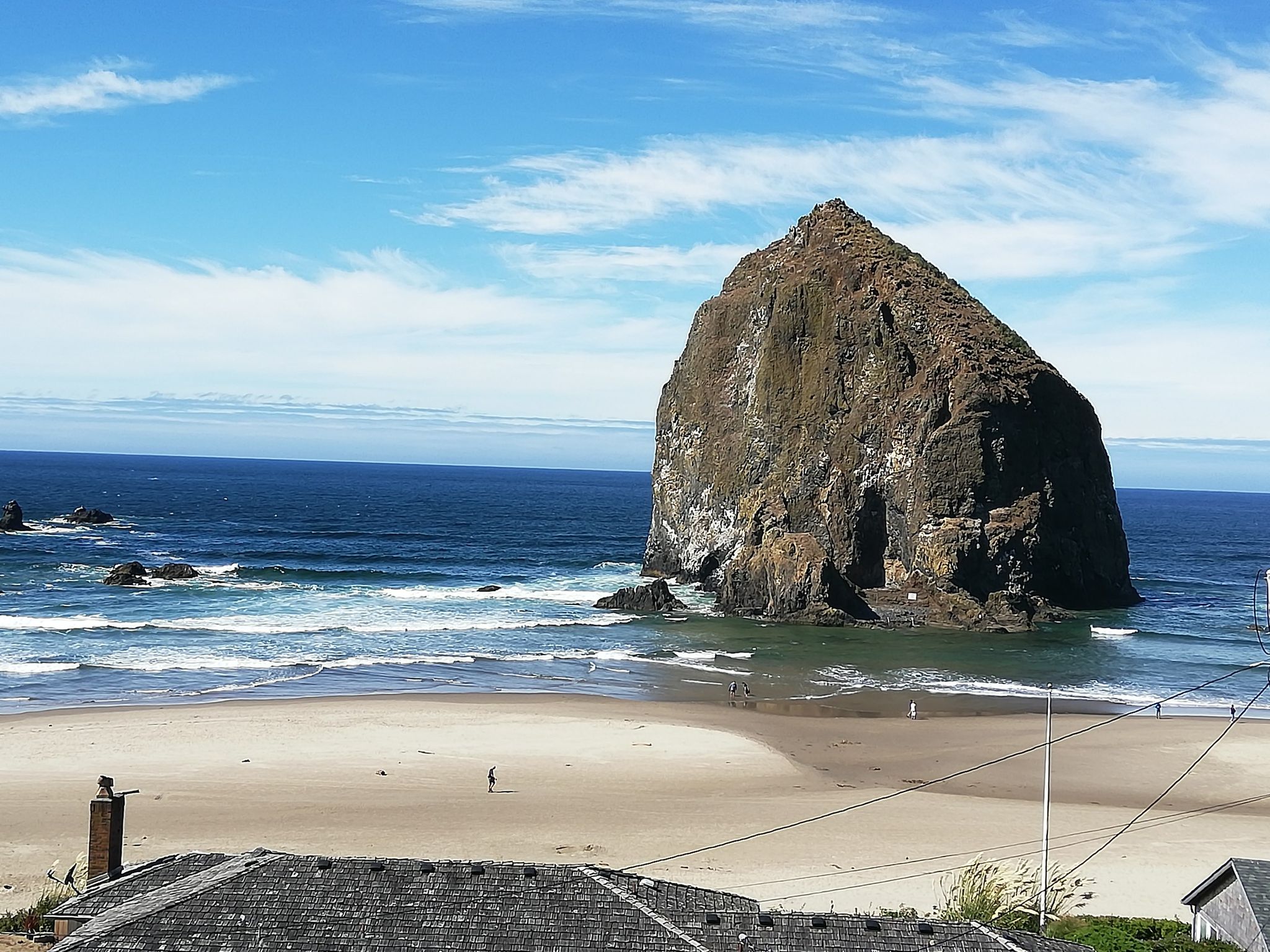 Sunny day with a large sea stack, blue ocean, and sandy beach. - Haystack Rock & Elk Creek Road loop