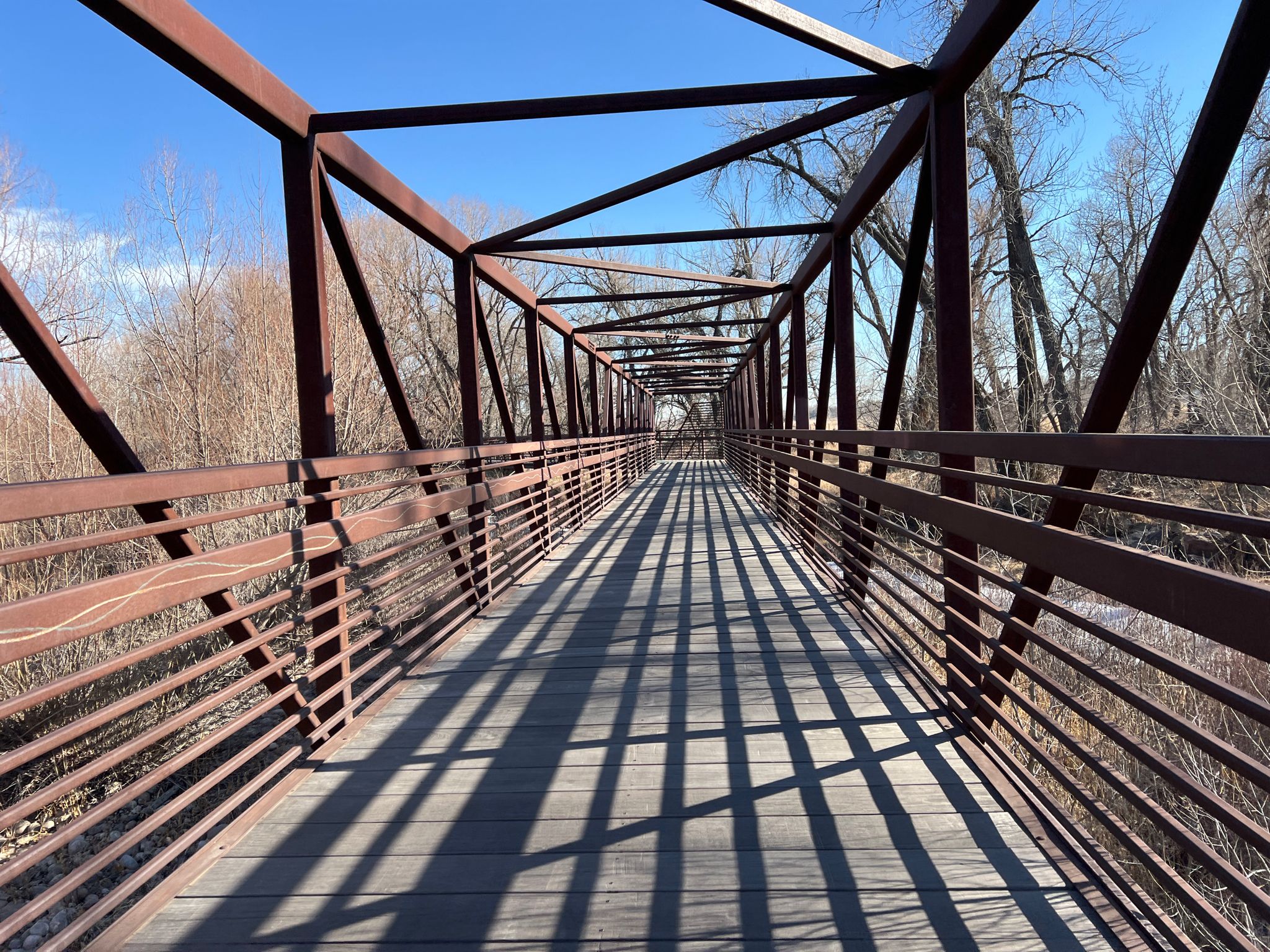 Long metal pedestrian bridge with strong shadows on a sunny day. - Sheldon Lake – Reservoir Ridge Natural Area loop from City Park