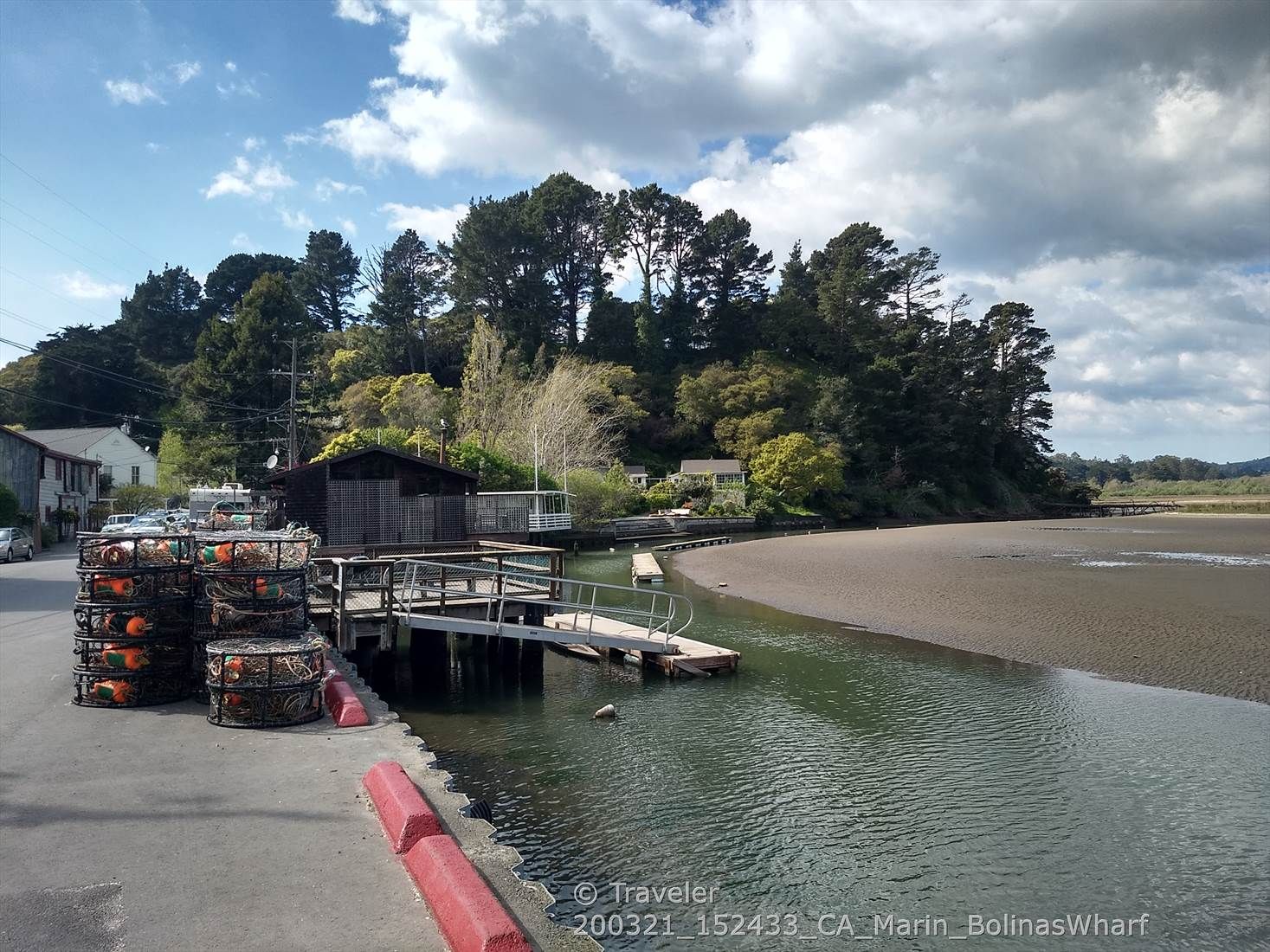 Crab pots stacked by a dock on a sunny, partly cloudy day. - Bolinas Lagoon via Marin Coastal Bike Route