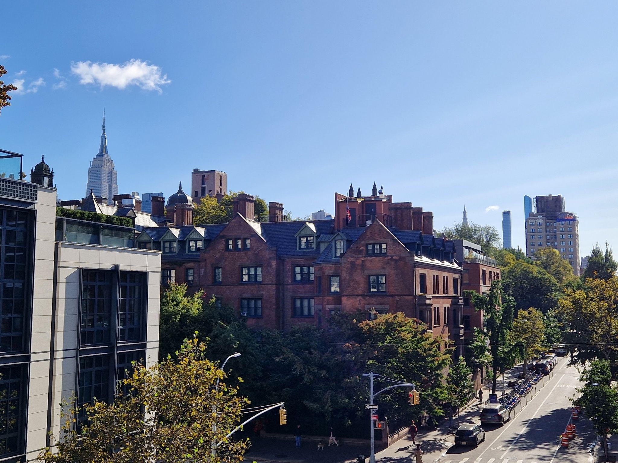 Sunny cityscape with historic brick buildings, modern towers, and a busy street. - High Line, Chelsea, and Flatiron Loop