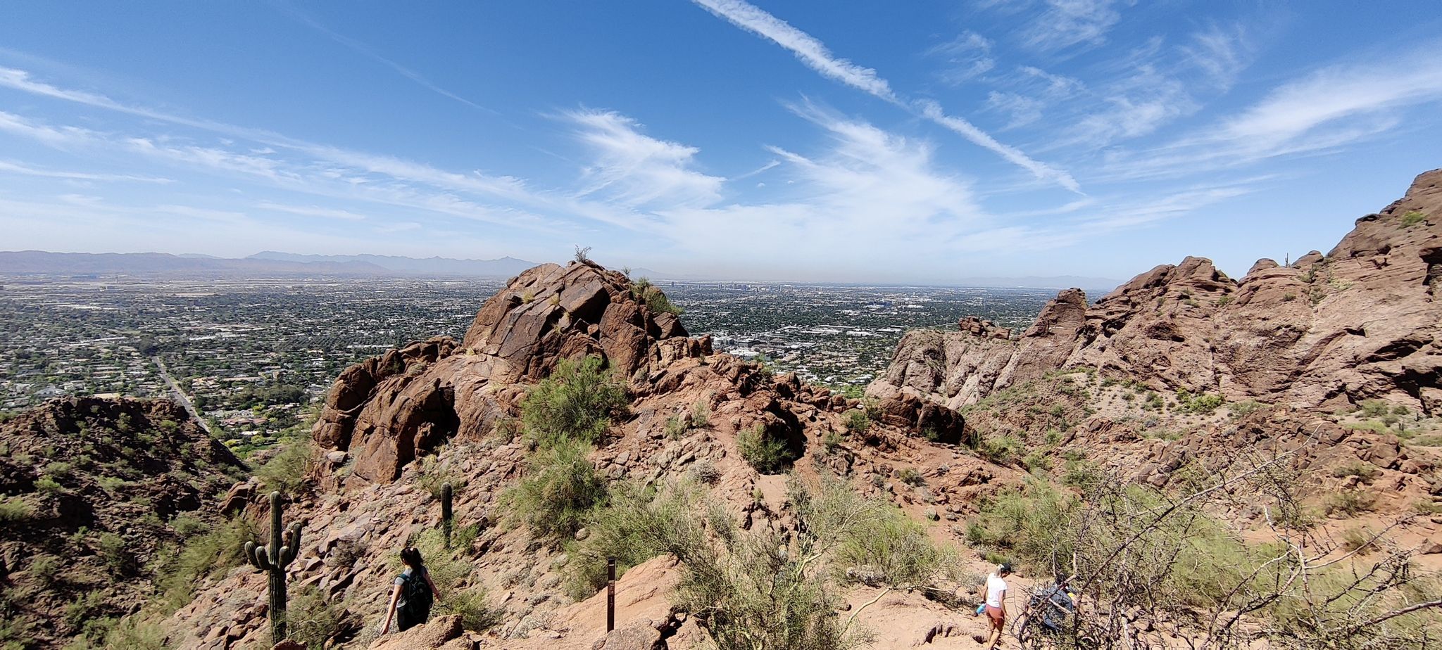 Panoramic city view from rocky mountain, person hiking, bright day. - Camelback Mountain via Echo Canyon Trail – Scottsdale, Arizona
