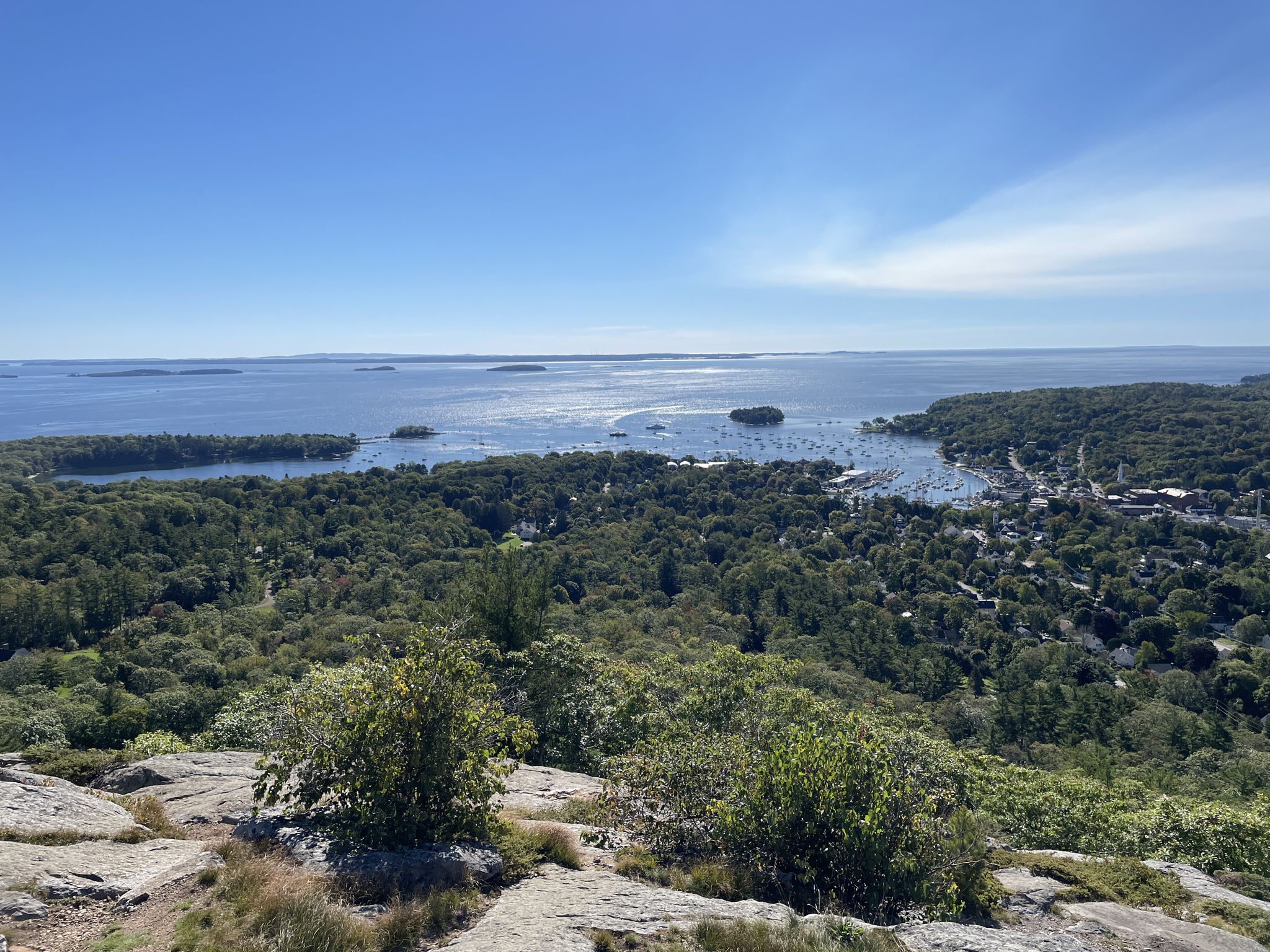 Panoramic view of a bay, islands, and forested landscape on a clear day. - Mount Battie Trail