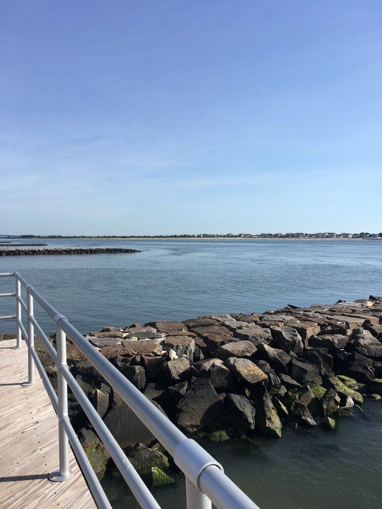 Calm blue water with rock jetties under a clear sky, from a pier. - Atlantic City Boardwalk – Atlantic City Beach loop from Jim Whelan Boardwalk Hall