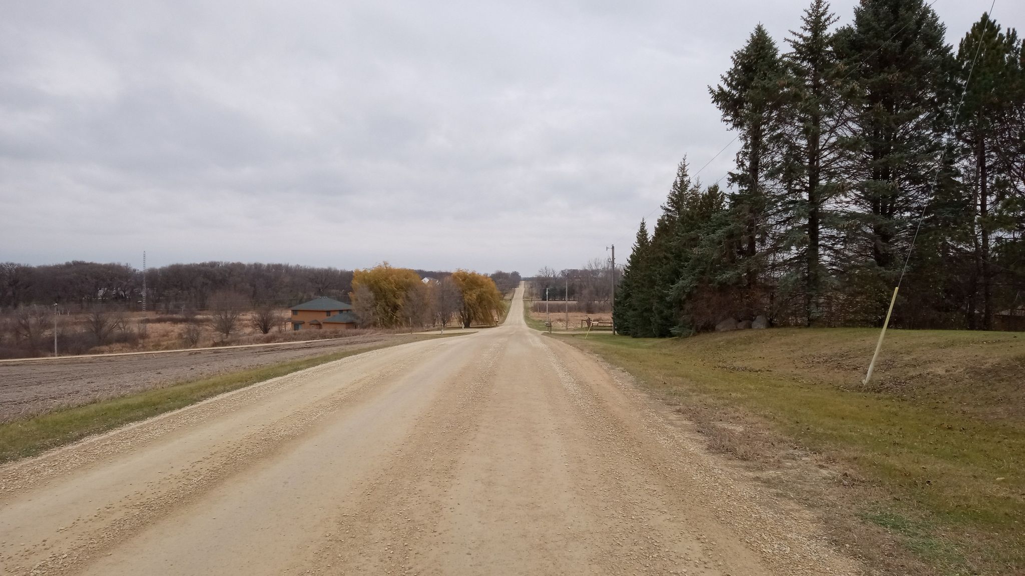 Long, straight dirt road extending into the distance under a cloudy sky. - Waterford to Chub Lake Wildlife Management Area gravel loop