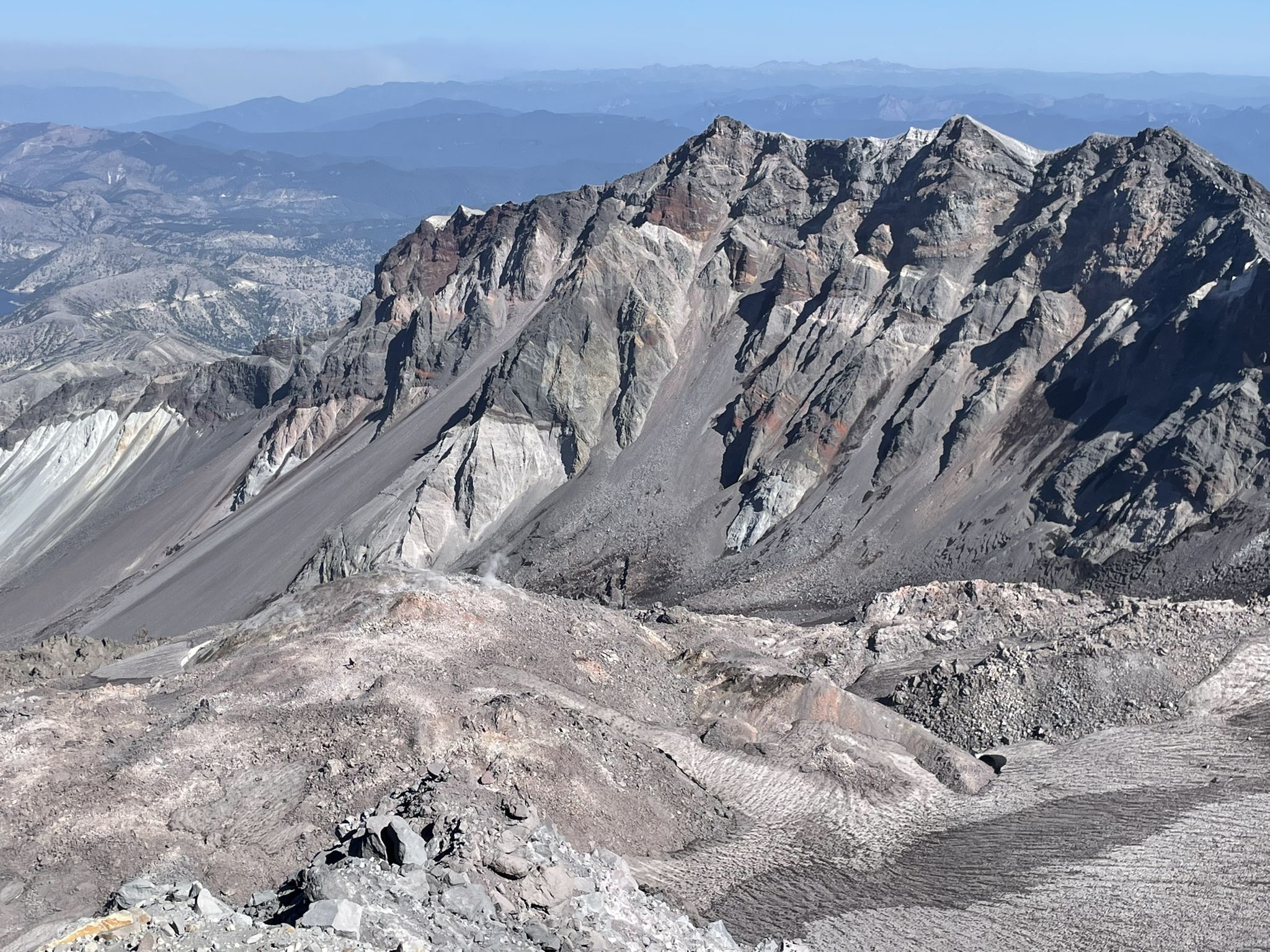 Rugged, barren mountain slopes under clear blue sky, distant hazy peaks. - Mount Saint Helens Summit via Ptarmigan Trail