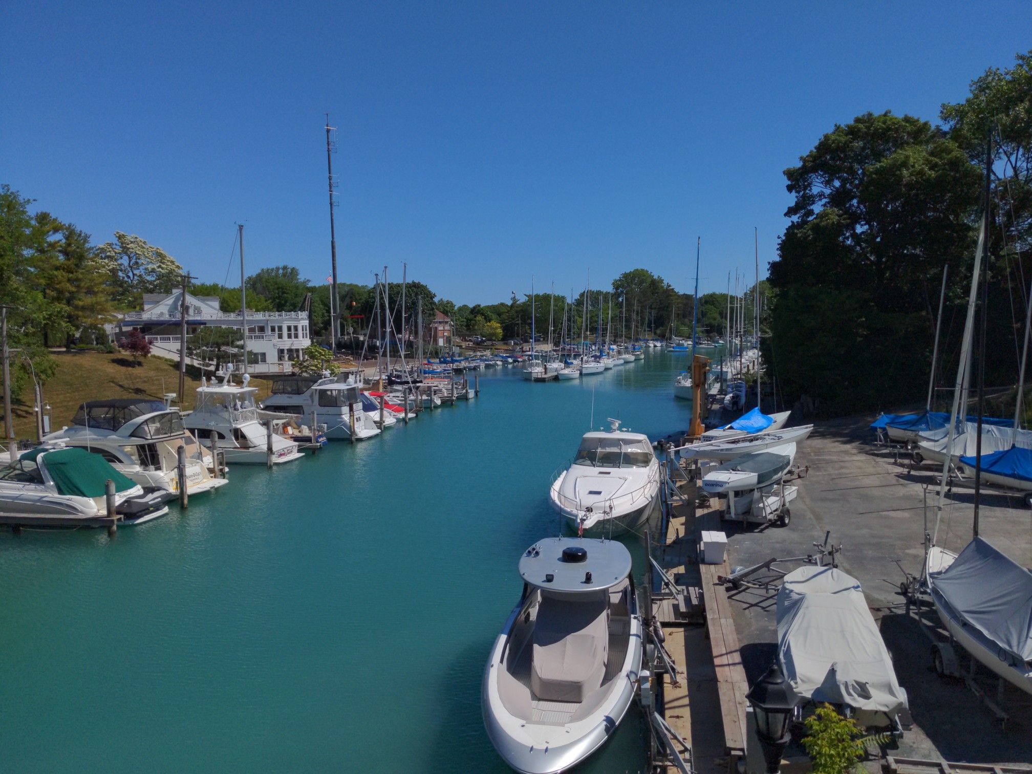 Boats docked in a turquoise canal, sunny day with clear blue sky. - North Branch Trail Loop