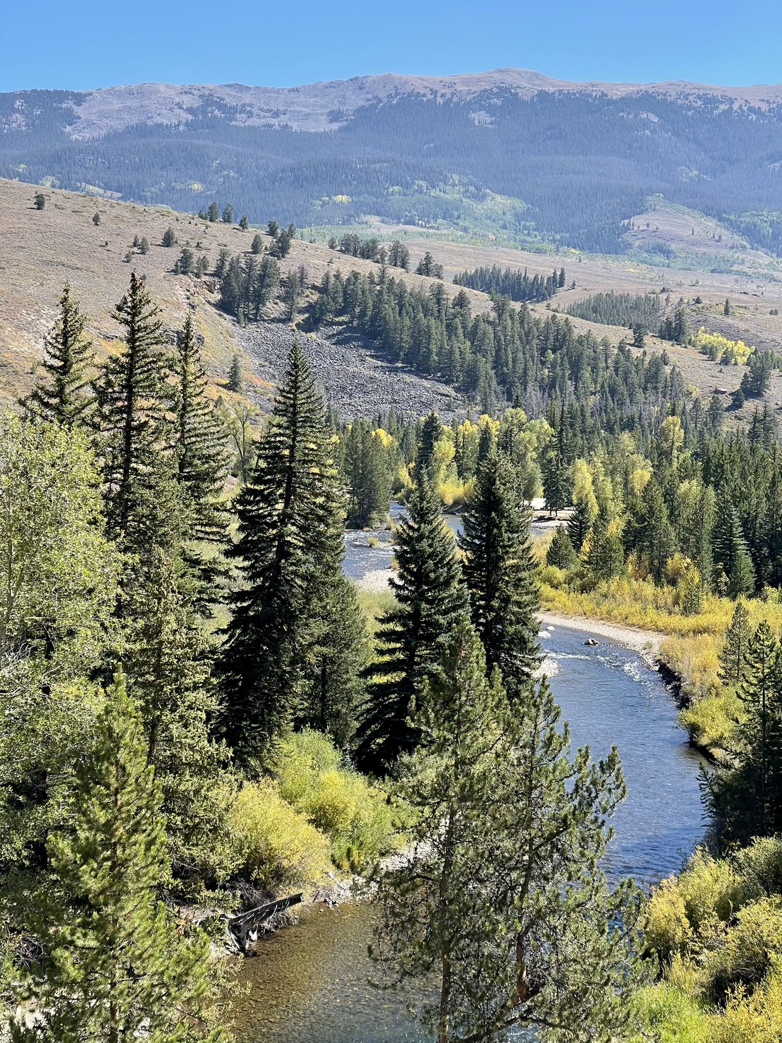 Clear day view of a winding river through a lush green valley. - Ute Pass from Silverthorne, Colorado