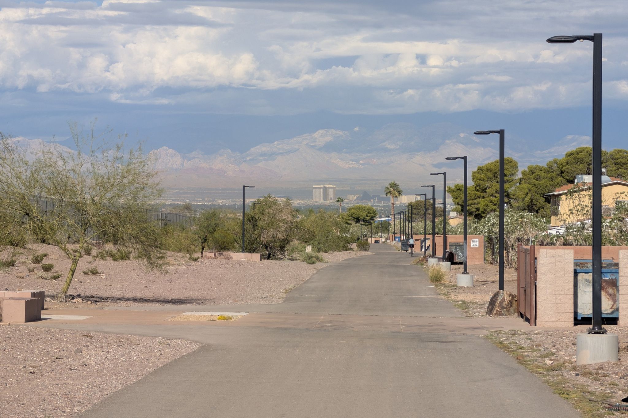 Paved path lined with streetlights, desert landscape, and distant mountains. - Acacia Park – Acacia Park loop from Coronado High School