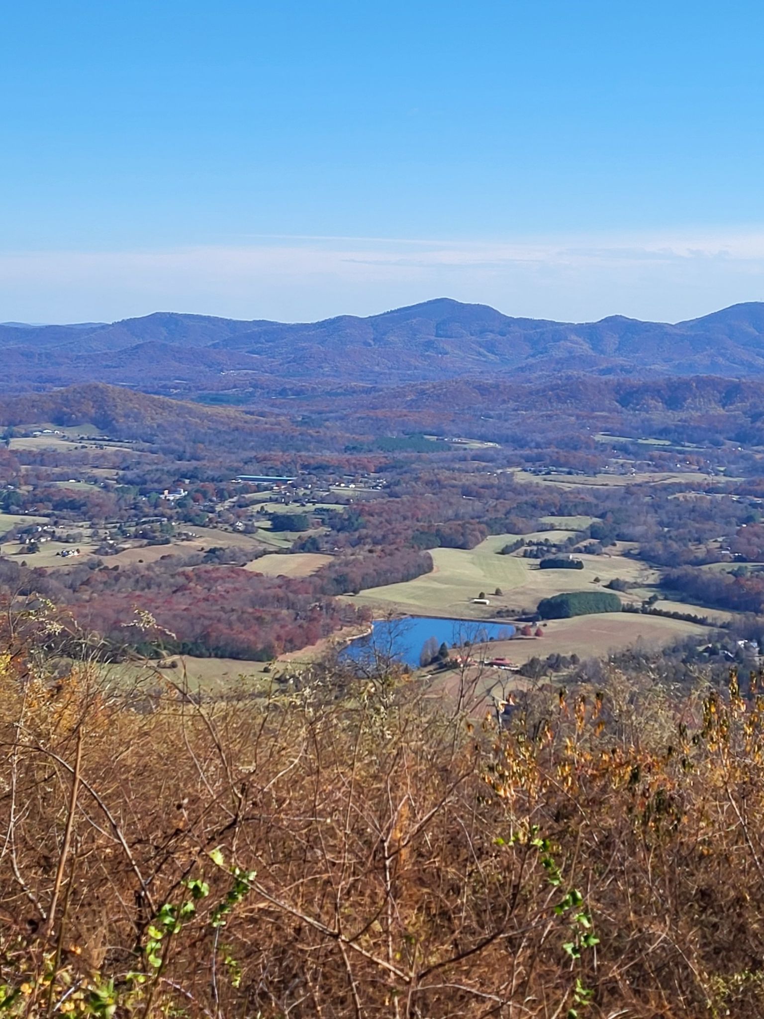 Vast mountain landscape with autumn trees, a lake, and clear blue sky. - Rockfish Valley Overlook – Afton Overlook loop from Little Spy Mountain