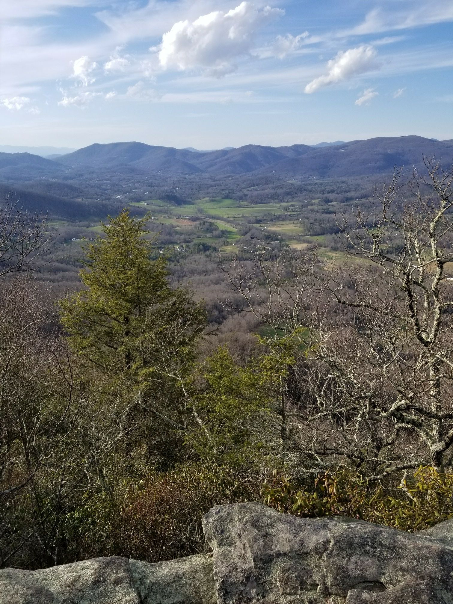 Sunny mountain vista overlooking a green valley with distant hills. - Strawberry Gap Trail