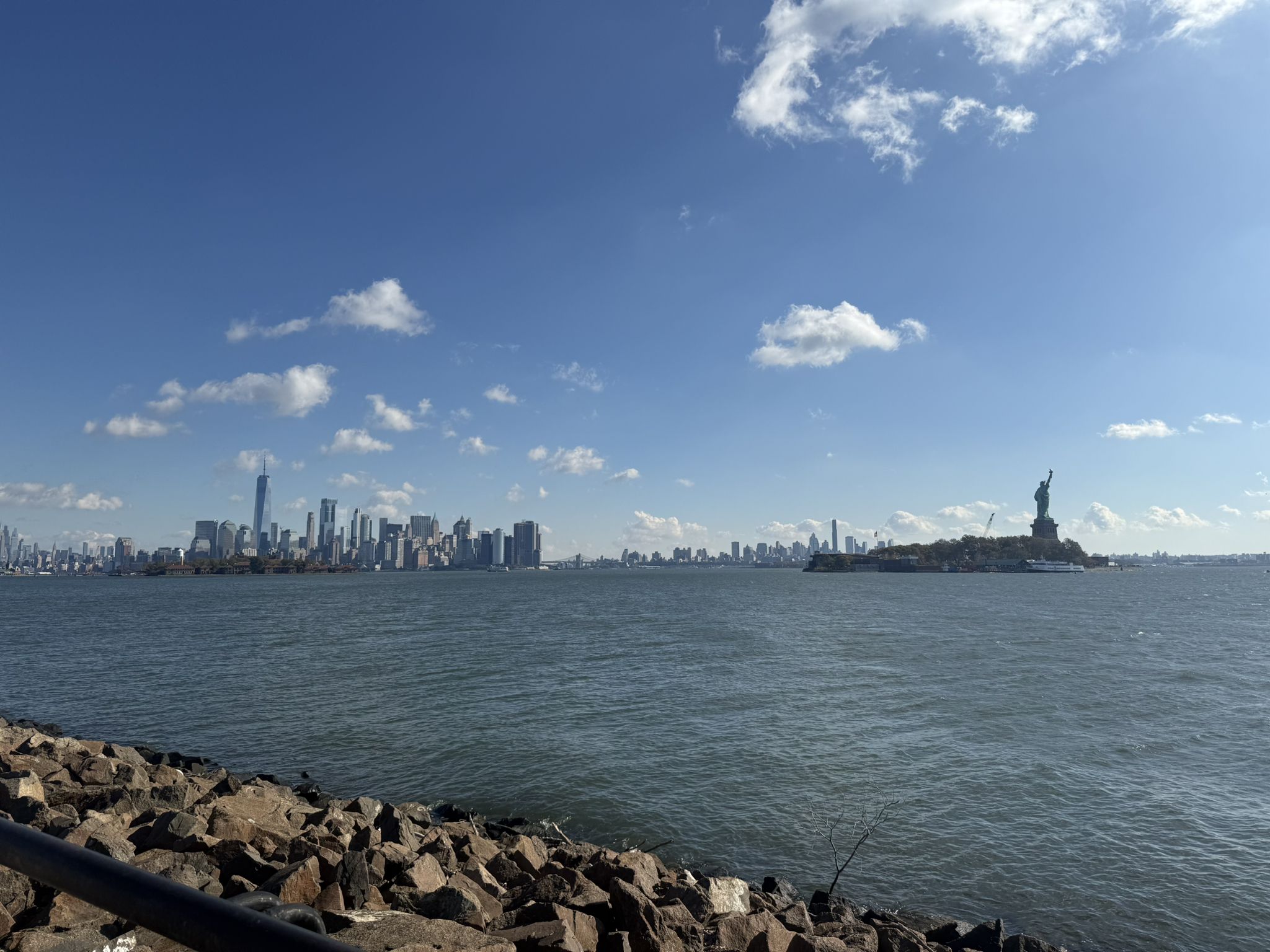 Distant city skyline and a large statue across wide water, sunny. - Richard J. Sullivan Natural Area Loop