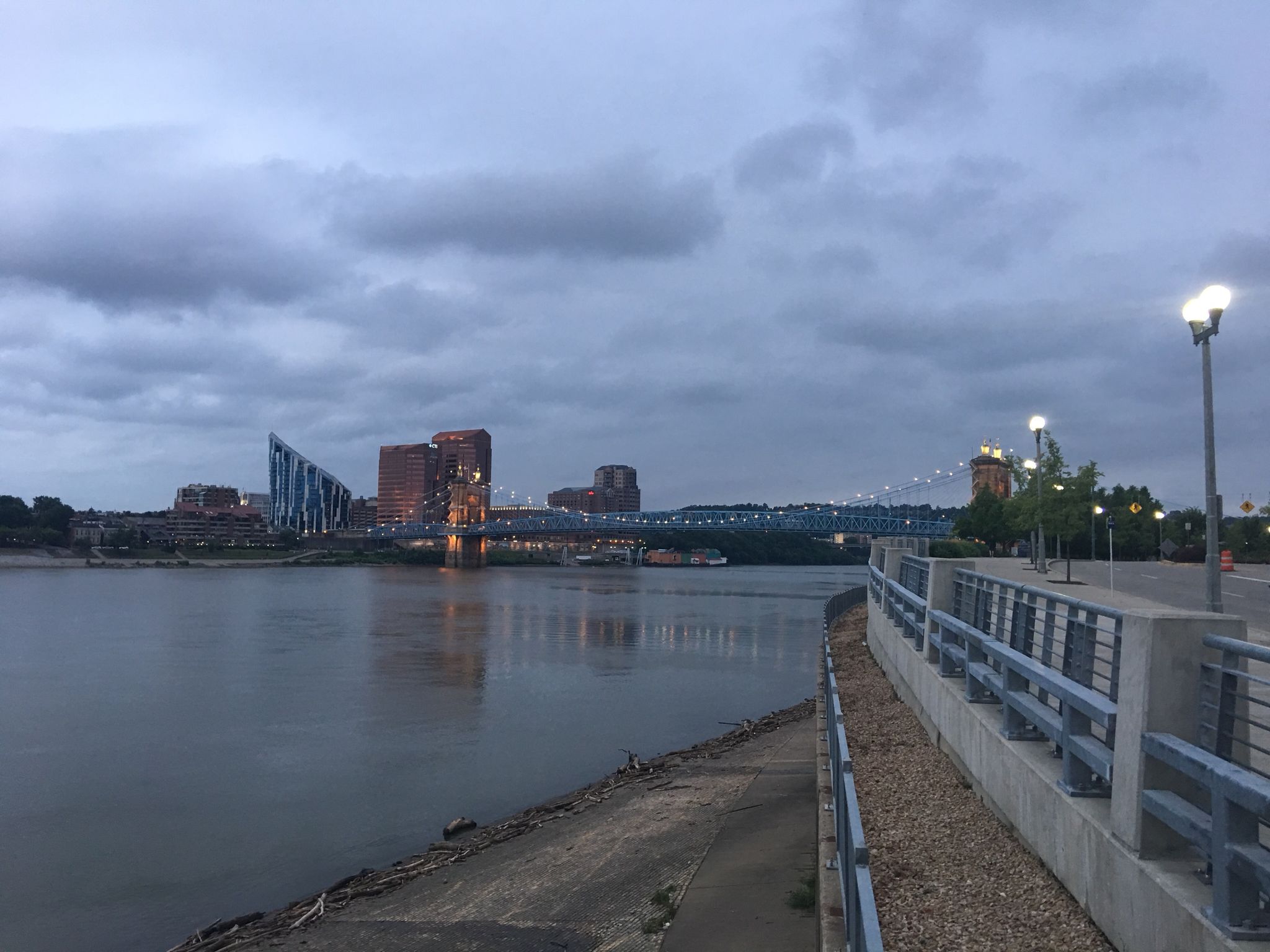 City skyline and bridge over river at dusk, with waterfront promenade. - Ohio to Erie Trail