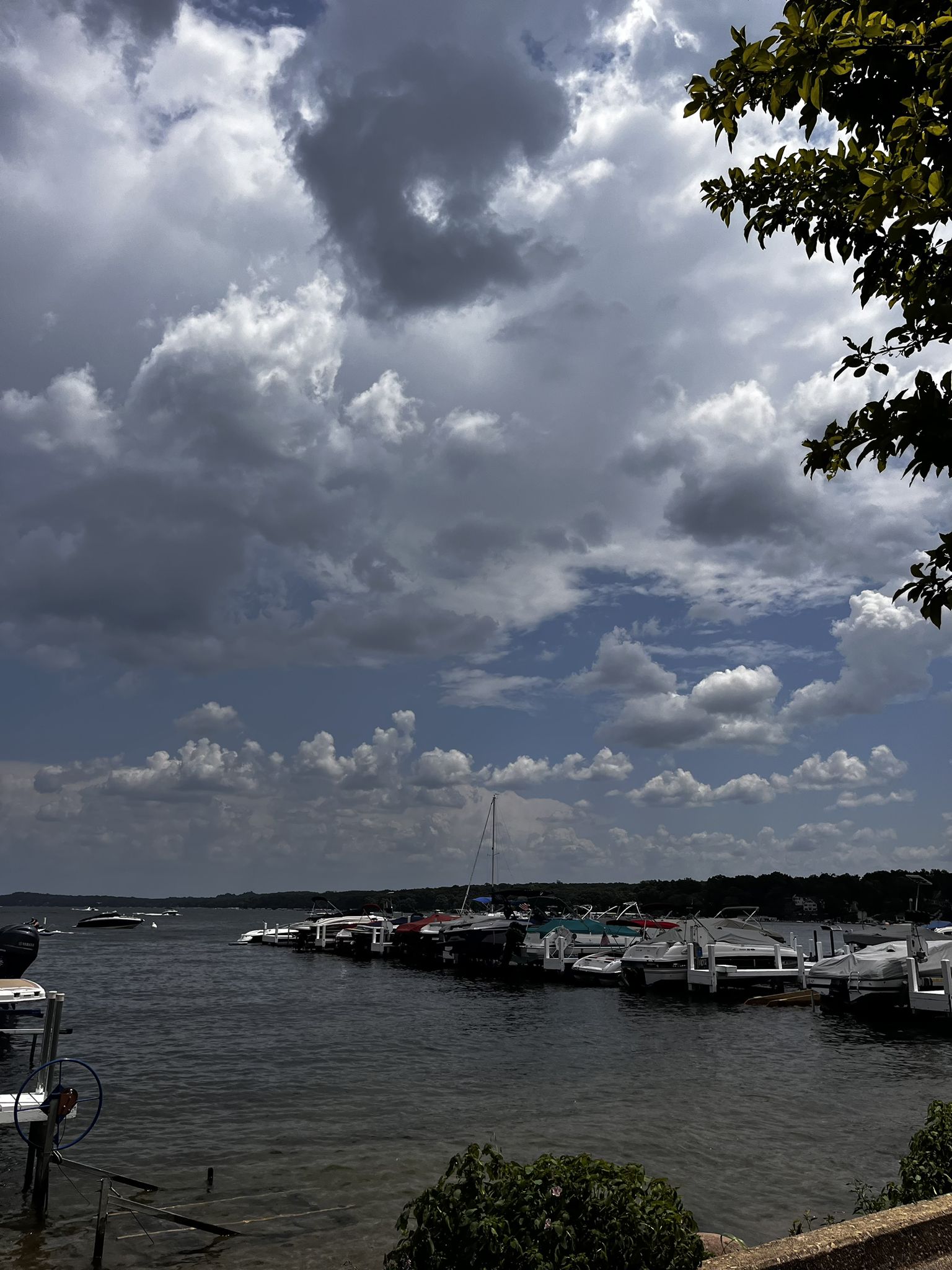 Boats docked in a marina under dramatic, cloudy skies with some blue. - Riviera Beach – Fontana Beach loop from Fontana-on-Geneva Lake