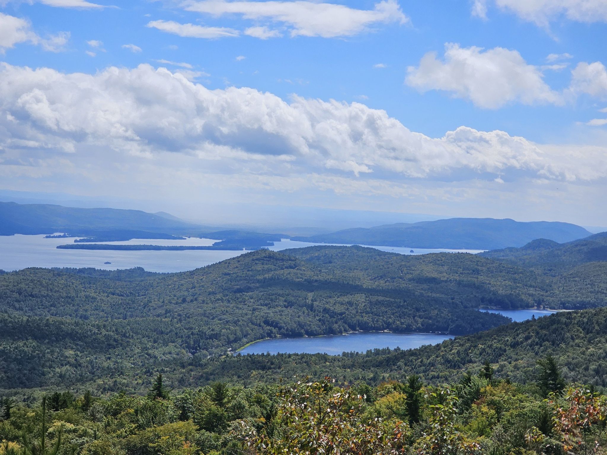 Expansive view of multiple lakes nestled among green forested mountains. - Cat Mountain via Red Trail