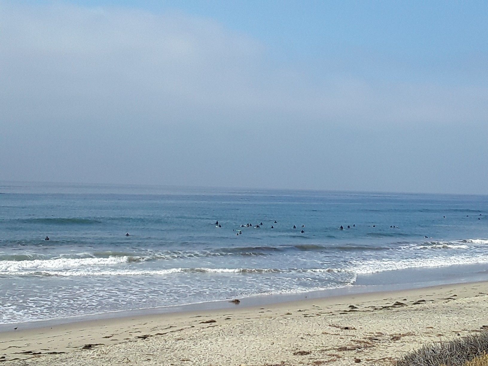 Beach with gentle waves and many surfers in the water. - Leo Carrillo State Park Beach – Leo Carillo State Park loop from Zuma Beach