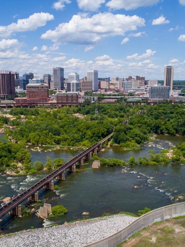 Aerial view of a city skyline, river with rapids, and a long bridge. - Virginia Capital Trail: Osborne Boat Landing Loop