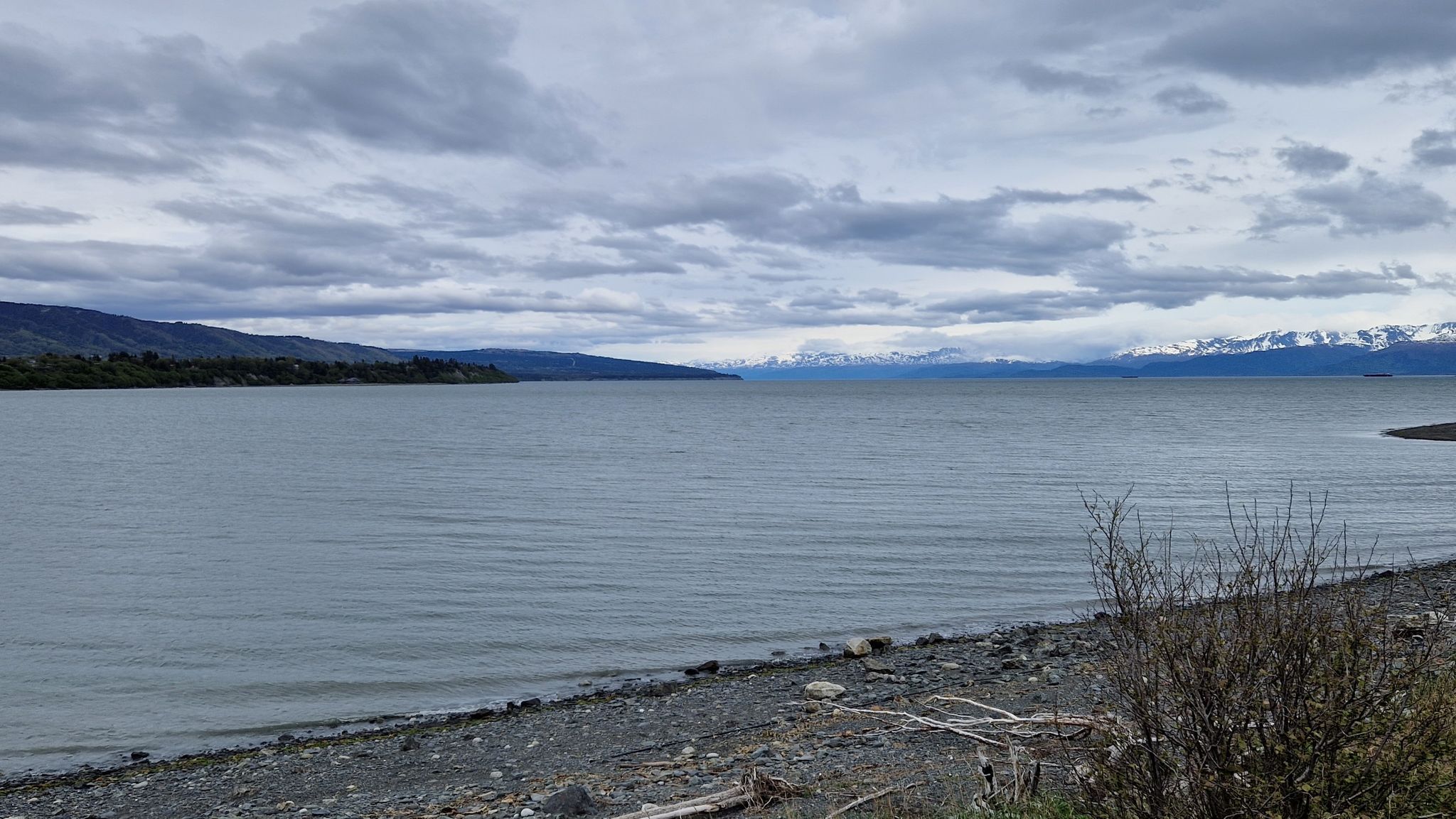 Cloudy day over a wide bay with distant mountains and a rocky shore. - Louie's Lagoon – Beluga Lake - Homer loop from Homer Spit