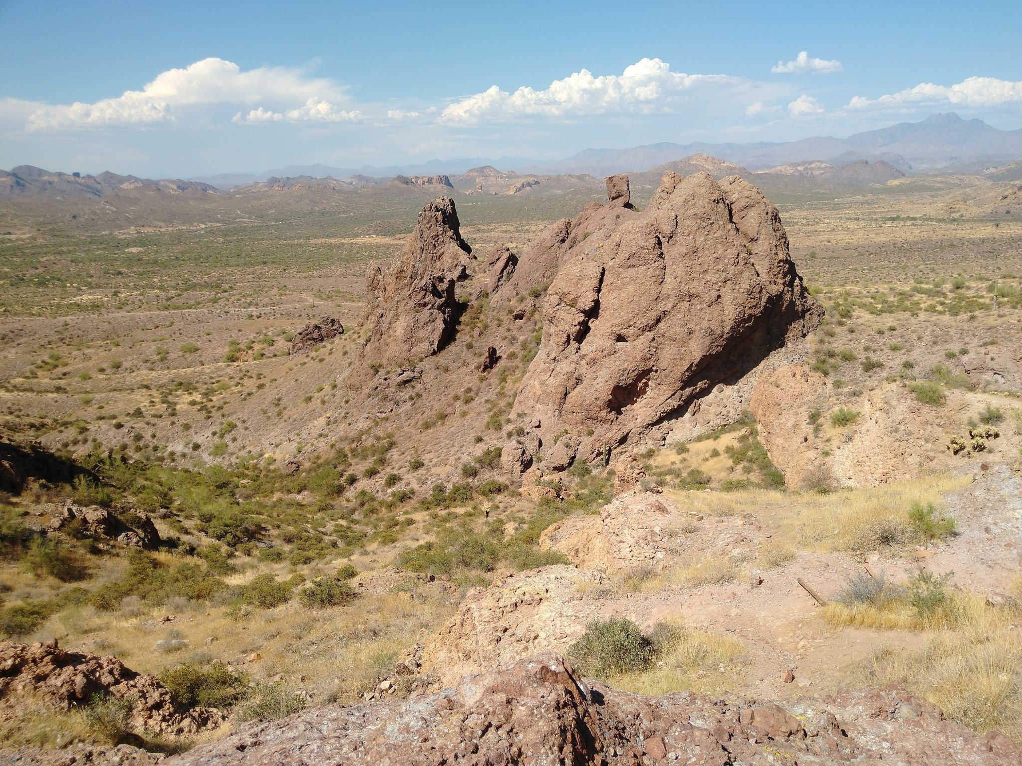 Expansive desert view with large rock formations and distant mountains under blue sky. - Jacob's Crosscut, Prospector's View and Treasure Loop