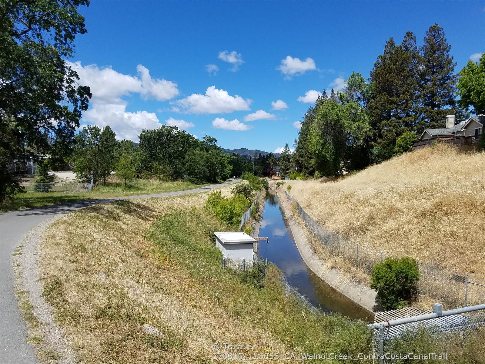 Paved path next to a fenced canal with dry grass and trees. - Iron Horse Trail – Iron Horse Trail junction loop from Concord