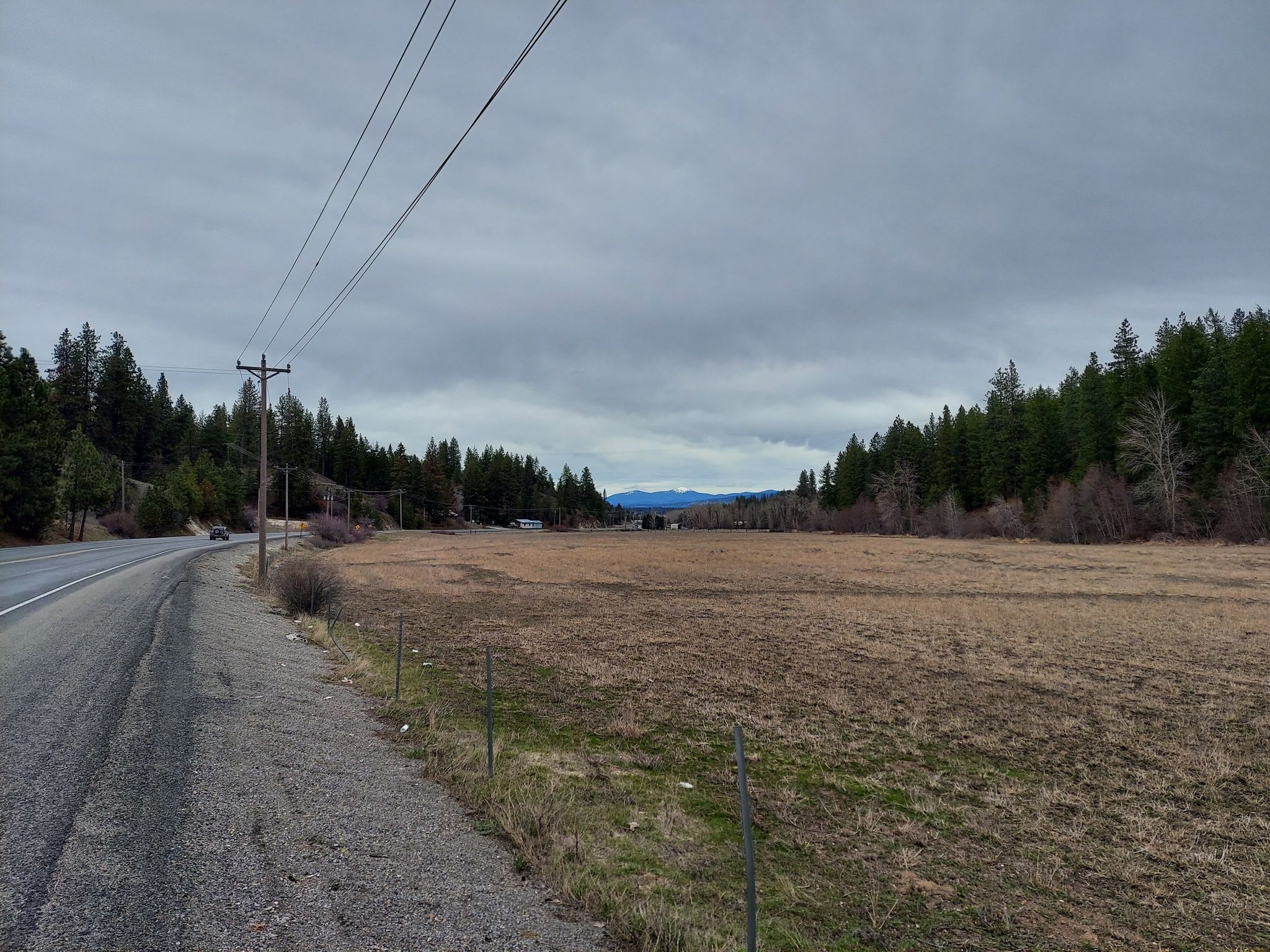 Overcast day showing a rural road next to a large brown field. - South Dishman Mica Road & East Elder Road gravel loop